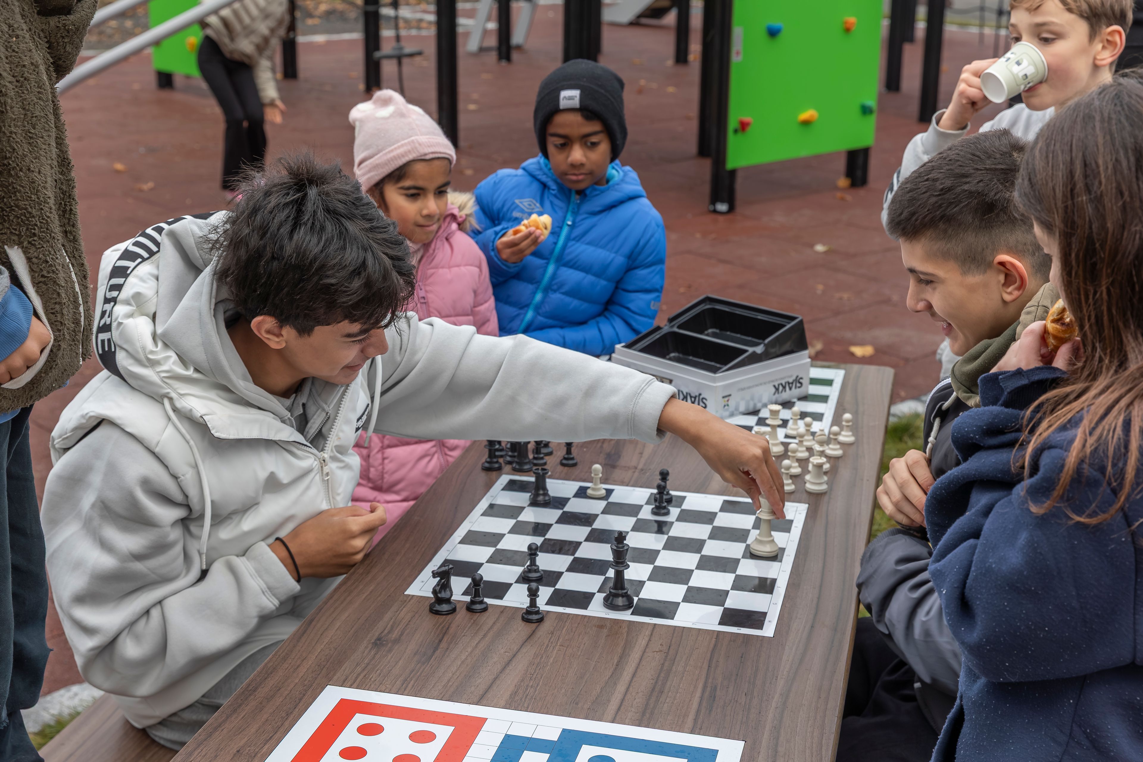 Barn spiller sjakk på en lekeplass