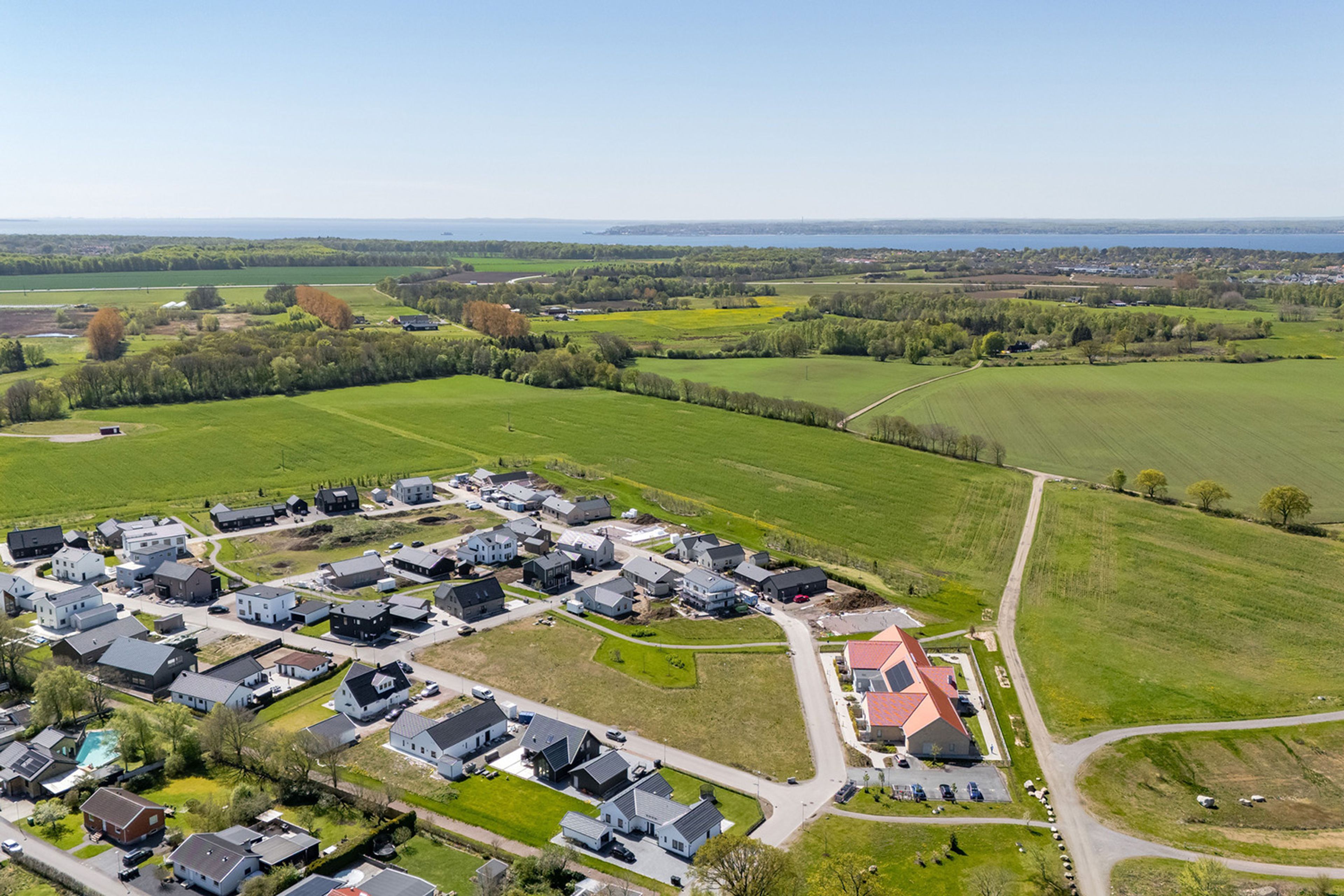 Flygfoto över tomten där Allerums Oas ska byggas. Fin vy över villatomter, öppna landskap och Öresund