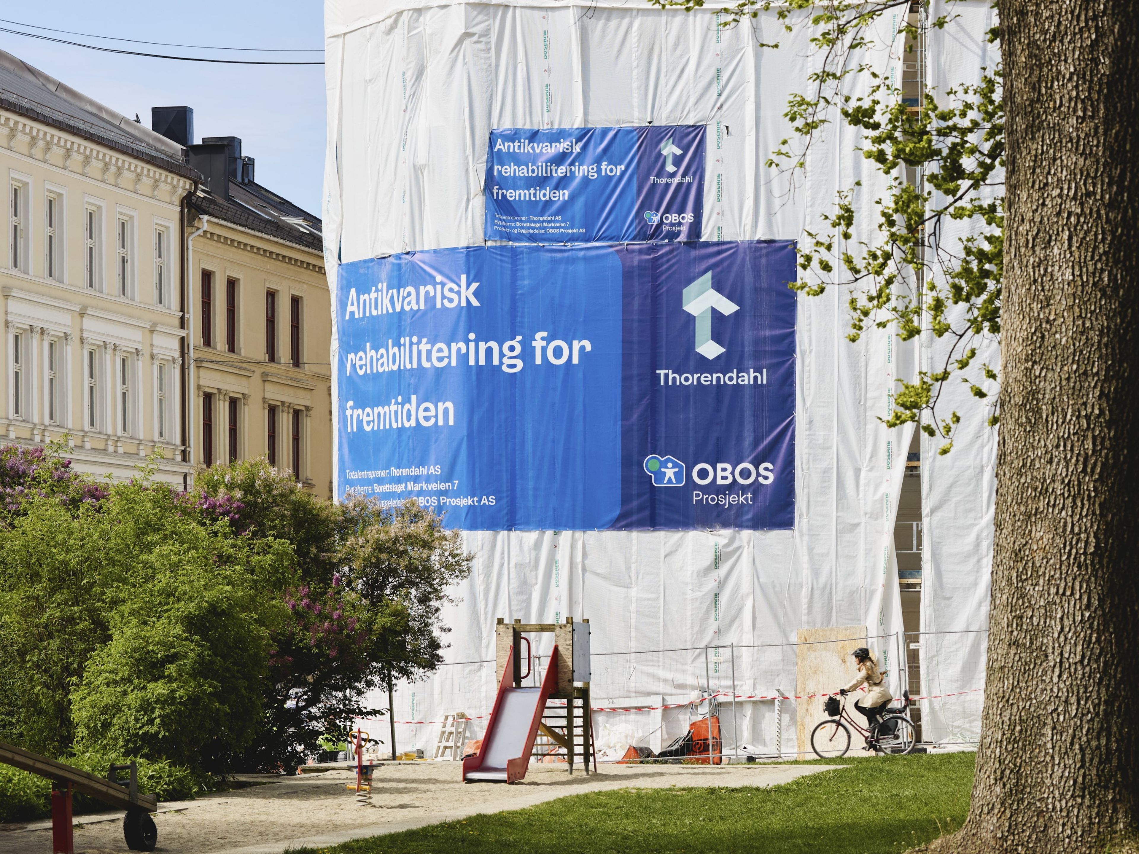 Gammel bygård er under rehabilitering. Bygården er dekket av stillas og presenning.
