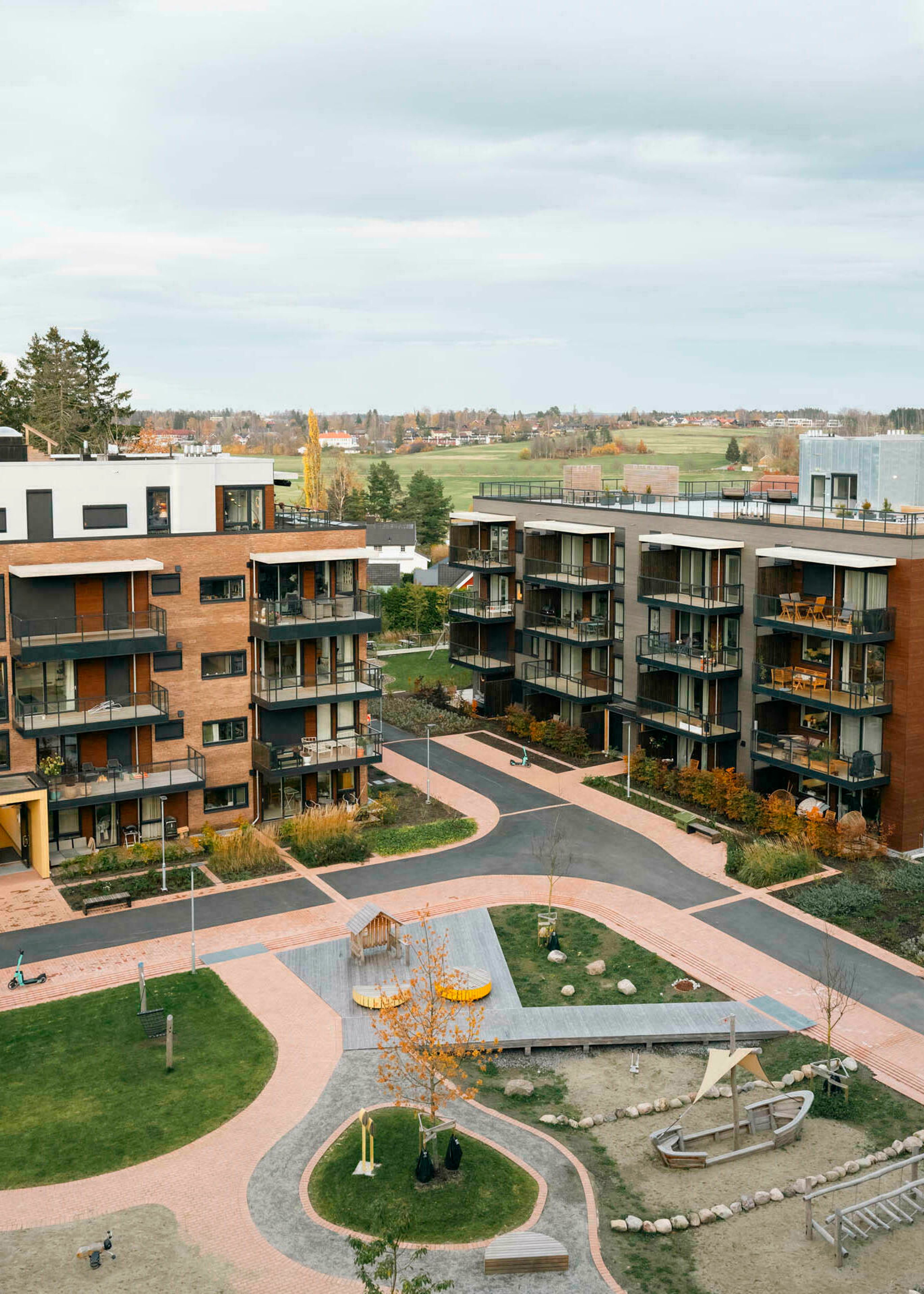 Oversikt over boligprosjektet Brekketunet og uteområdet mellom husene, sett fra terrasse.