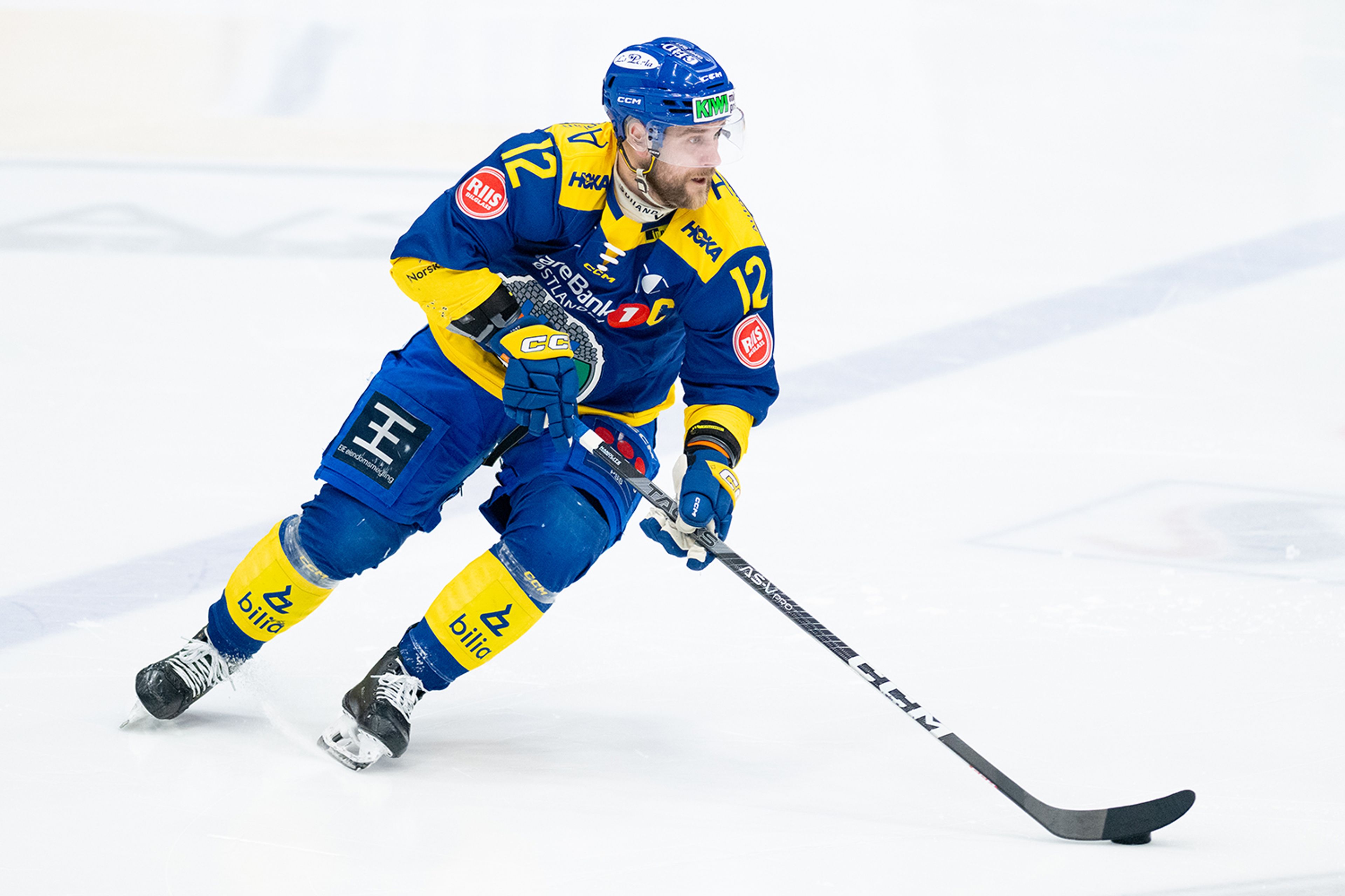 Ishockeyspiller i aksjon på banen i gul drakt