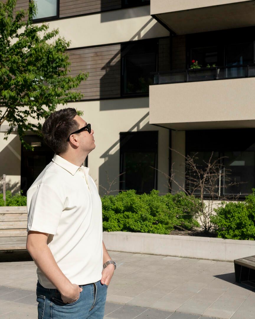 Foto av kjøperen Andreas utenfor Vollebekk Torgkvartal i sola.