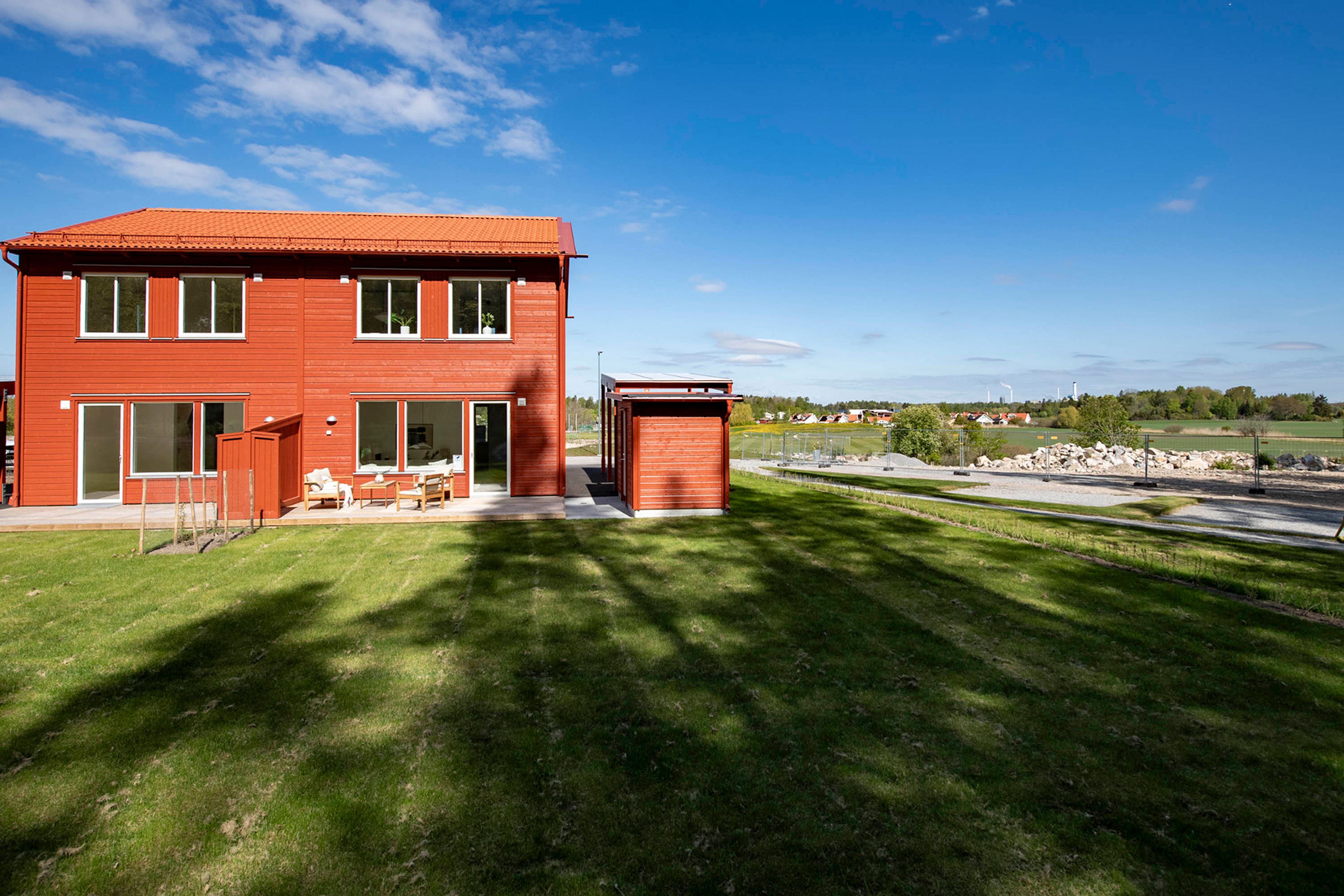 Rött parhus med stor trädgård och uteplats