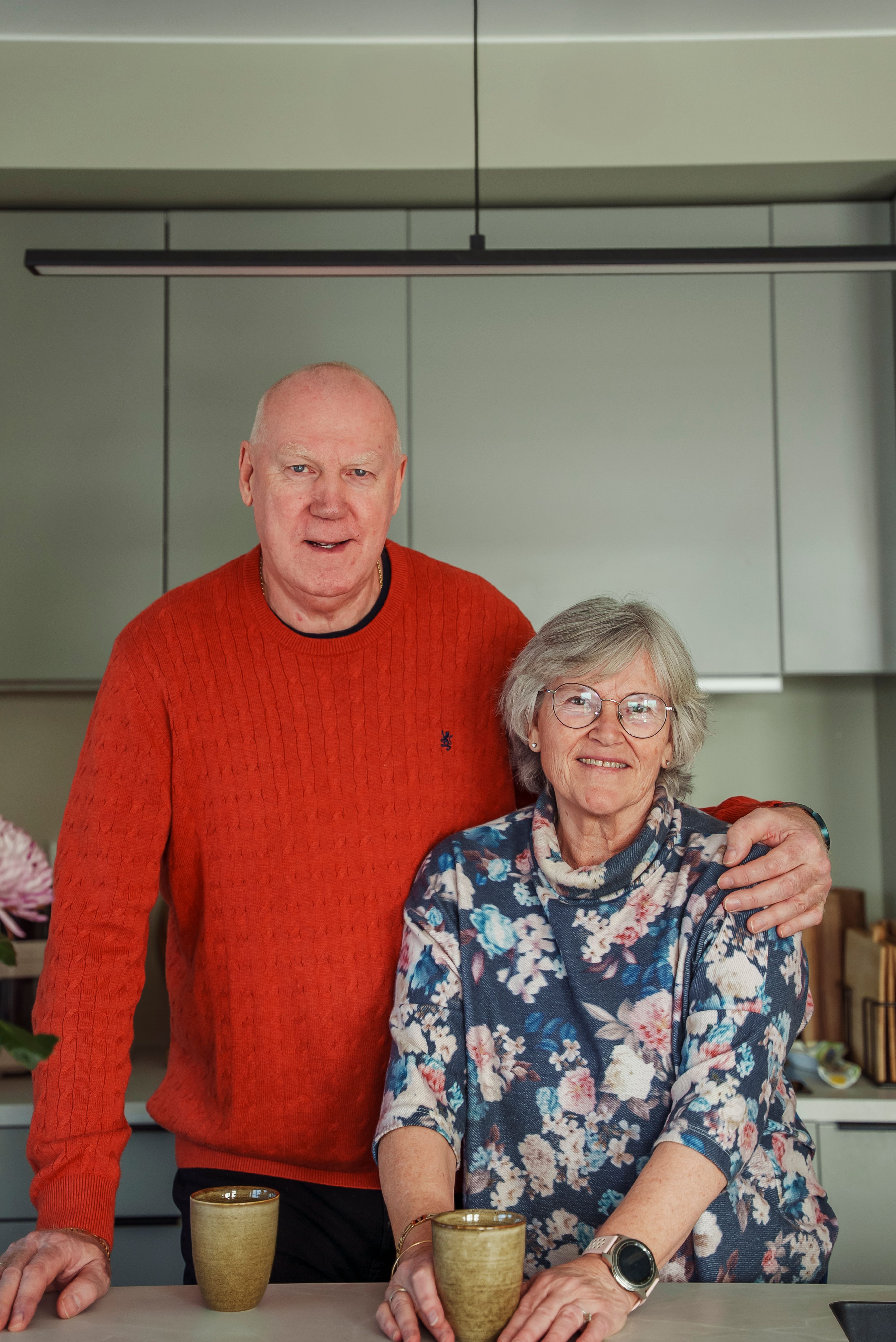 Bente og Arne står på kjøkkenet og smiler mot kamera.
