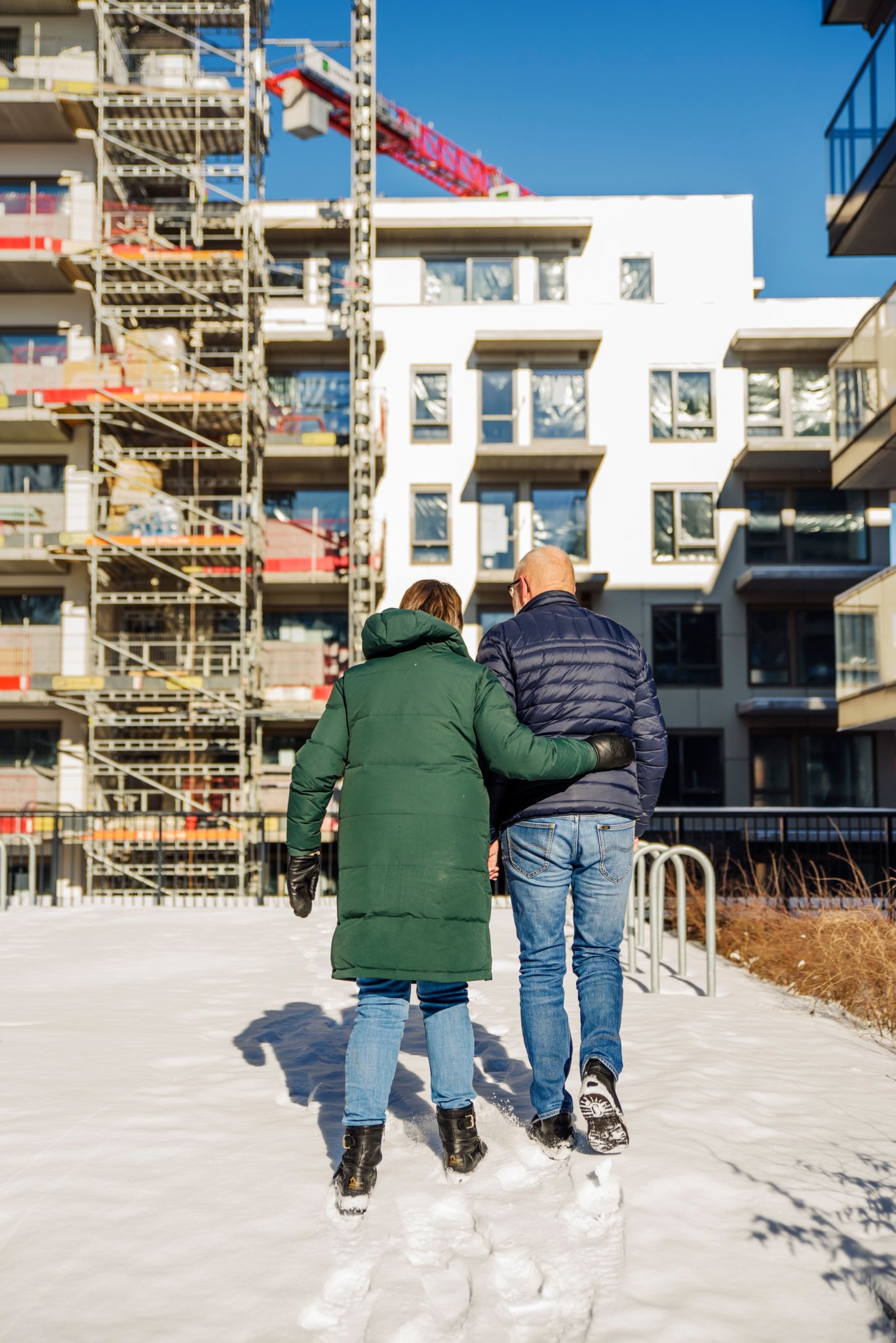 Frank og Ellinor Sengebusch går tur med ryggen til i snøen i en bakgård i boligprosjektet MIDT i Lørenskog