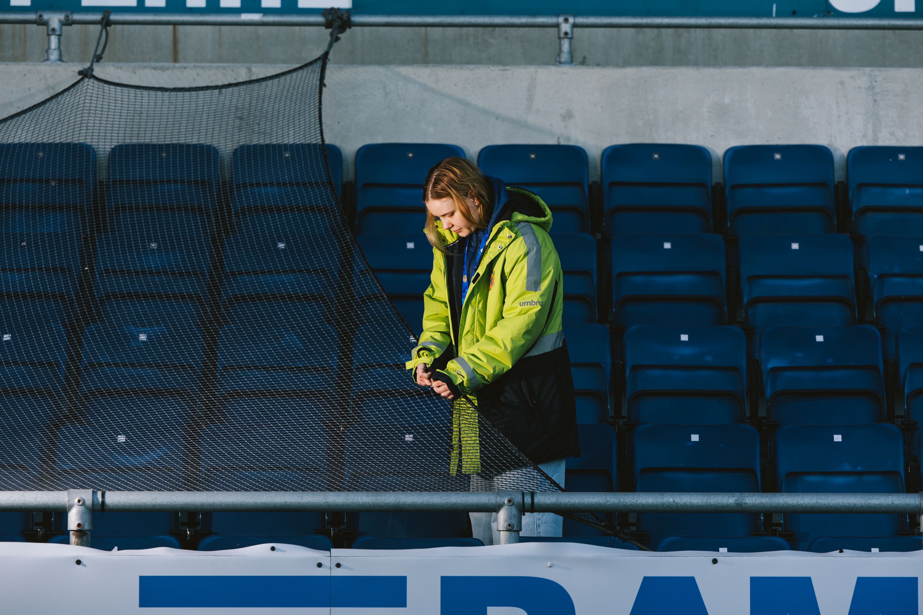 Kristina justerer sikkerhetsnettet bak tribunene som en del av kampforberedelsene på Color Line Stadion.