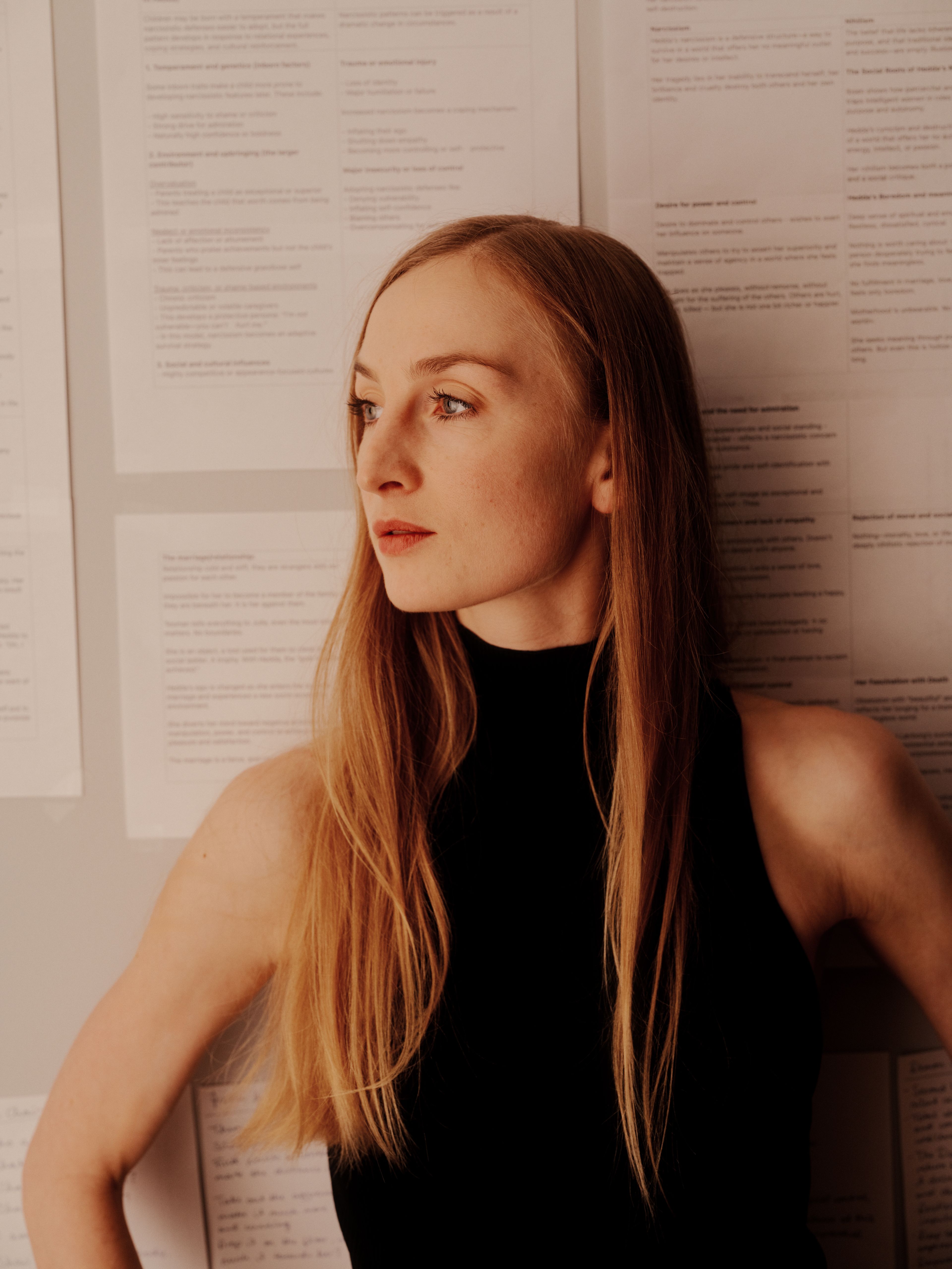 Grete Borud Nybakken lener seg mot veggen der manuset henger.