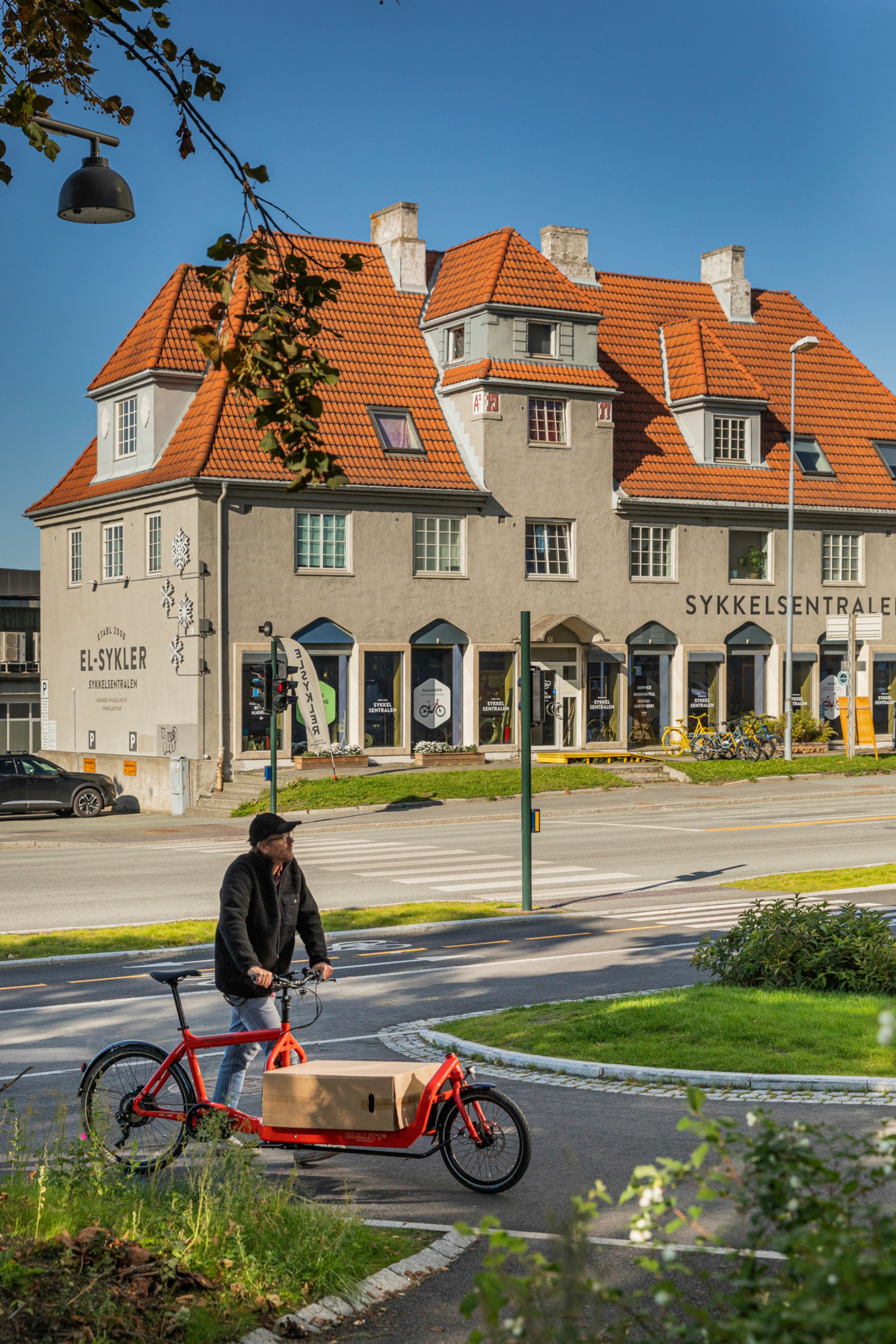 Mann med sykkel foran sykkelverksted på Jarlheim.