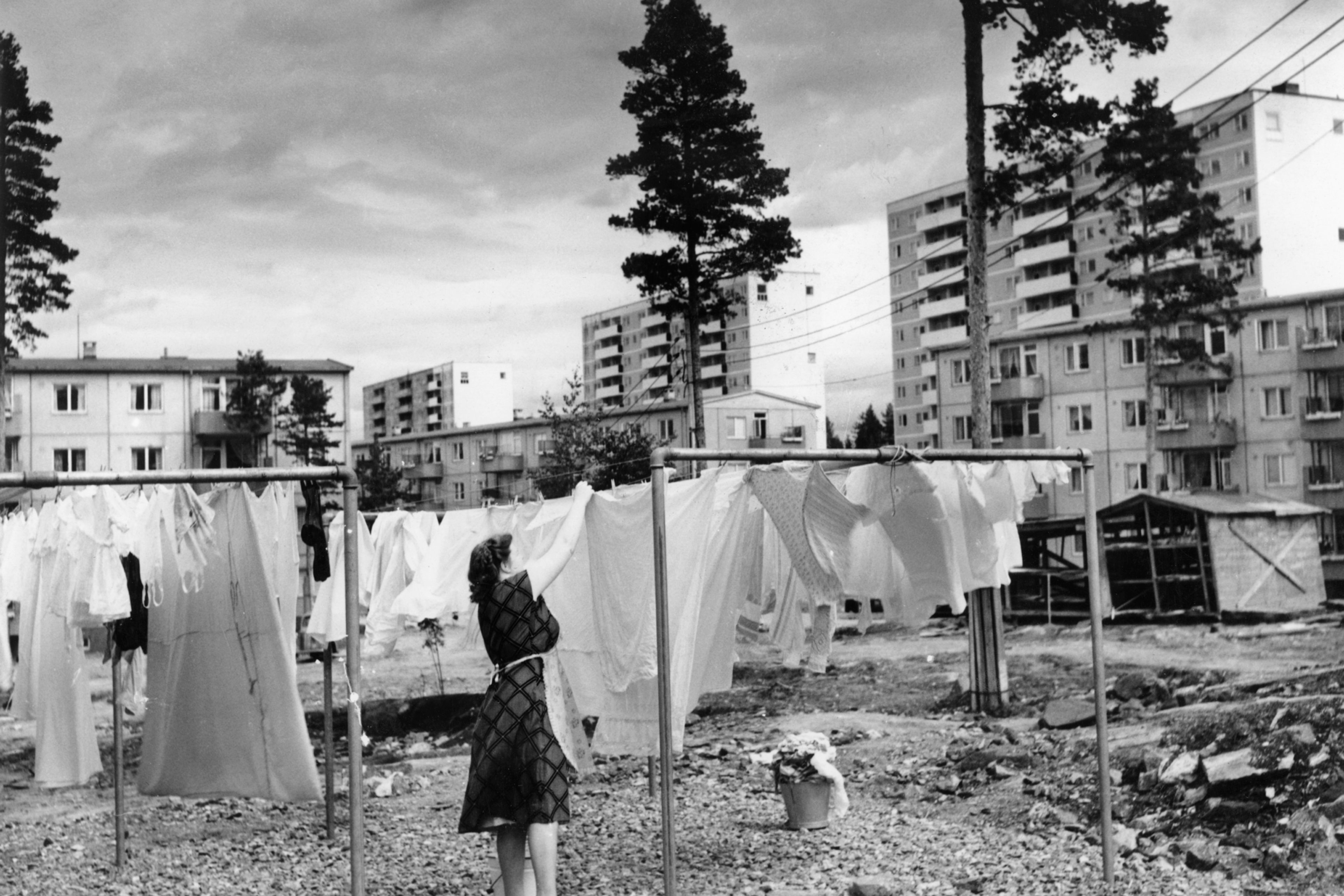 Arkivfoto fra Oslo kommune som viser en kvinne som henger opp klesvasken i bakgården.
