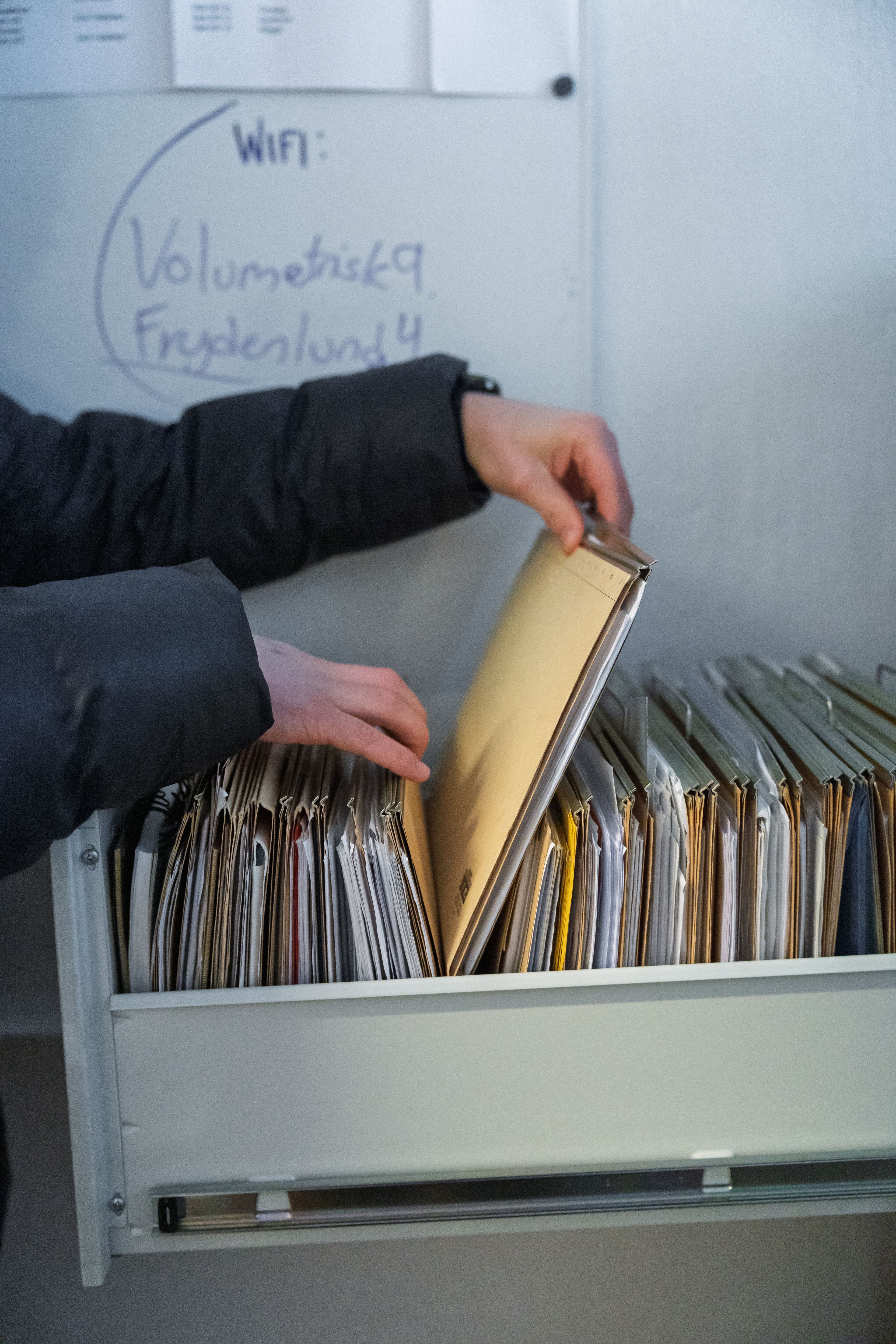 Nærbilde av at Iben blar i et arkiv.