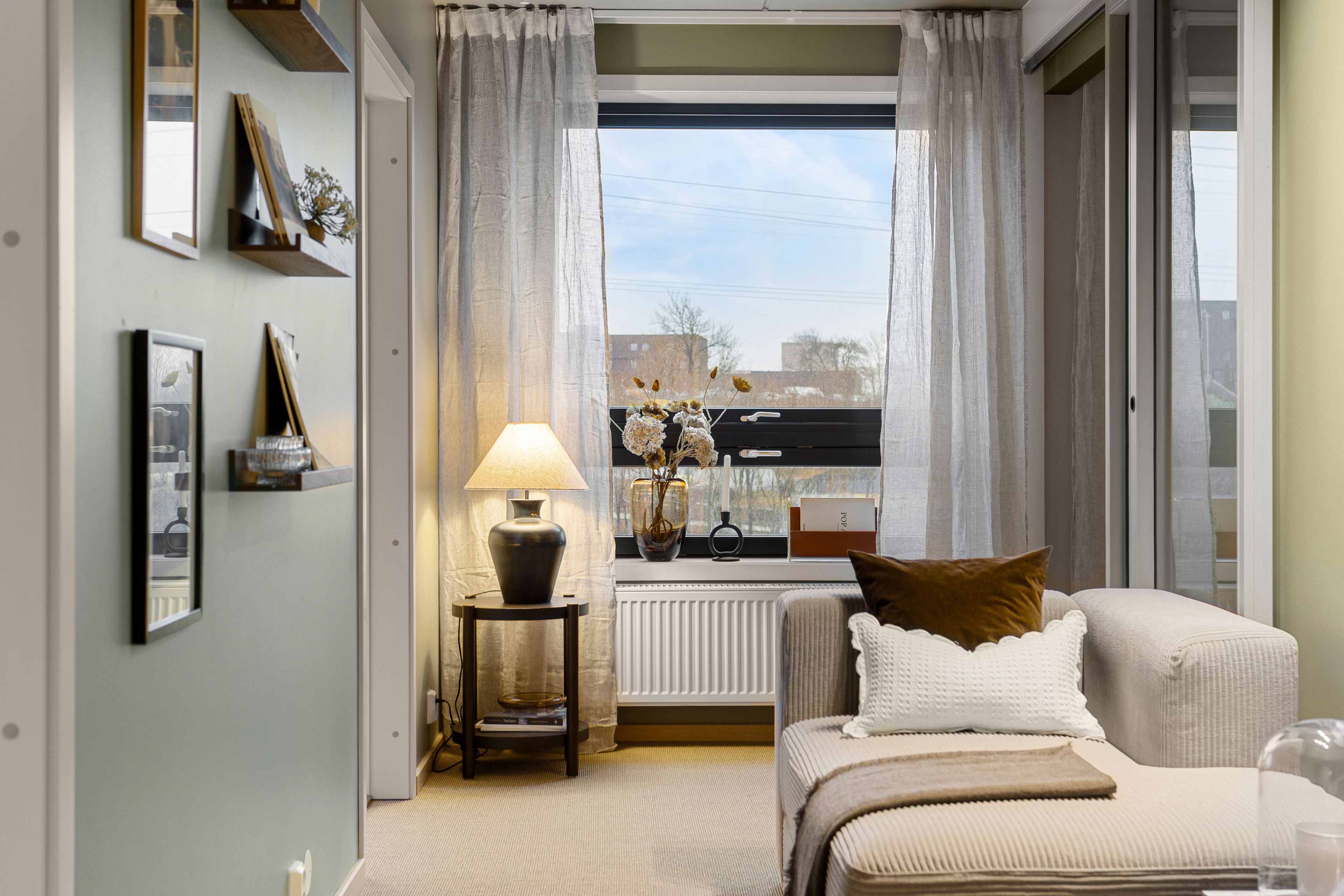Stue med sofa og liten lampe. Vindu og skyvedør