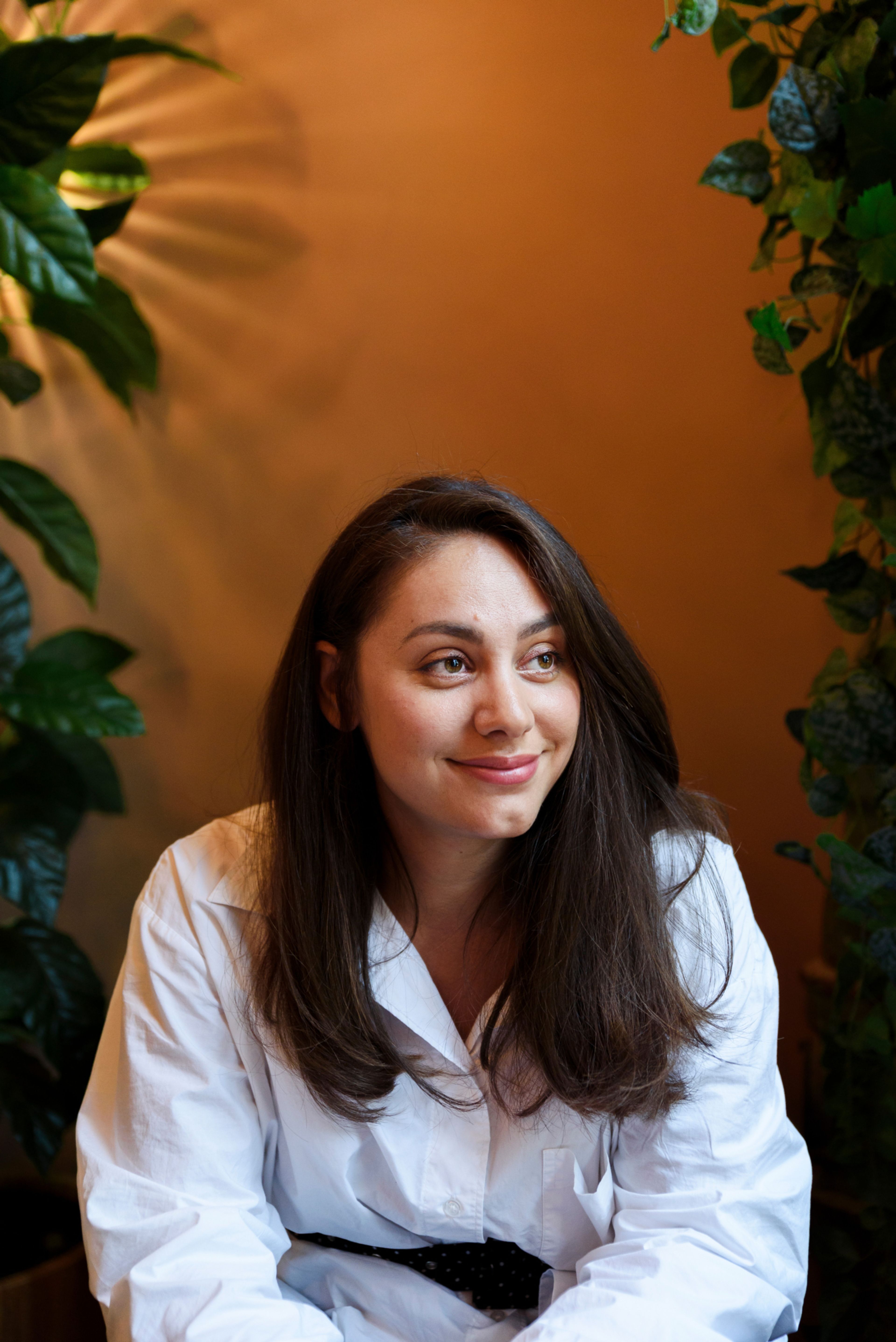 Jenny Andersen sitter foran en oransje vegg