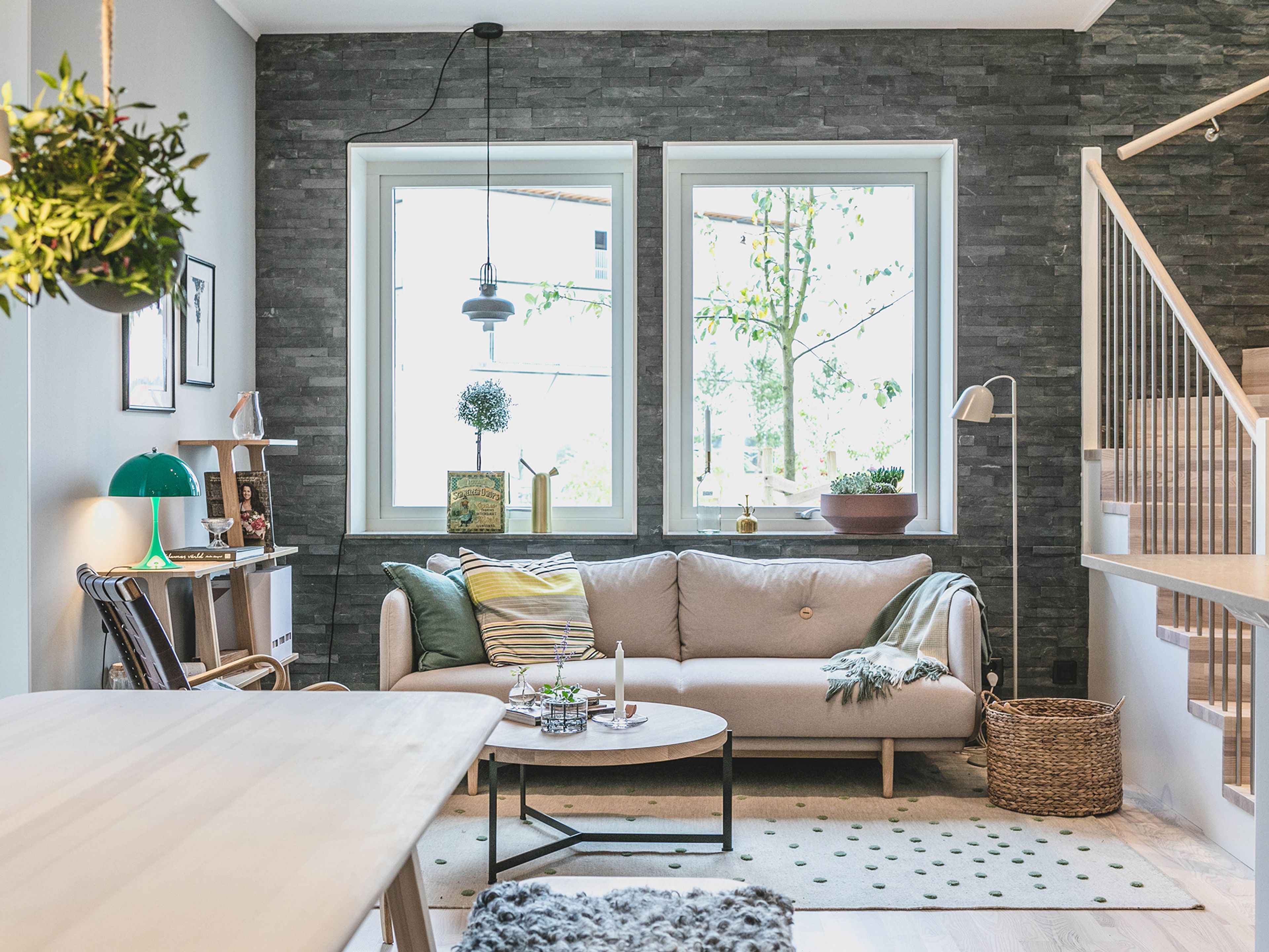 En liten beige soffa i ett vardagsrum