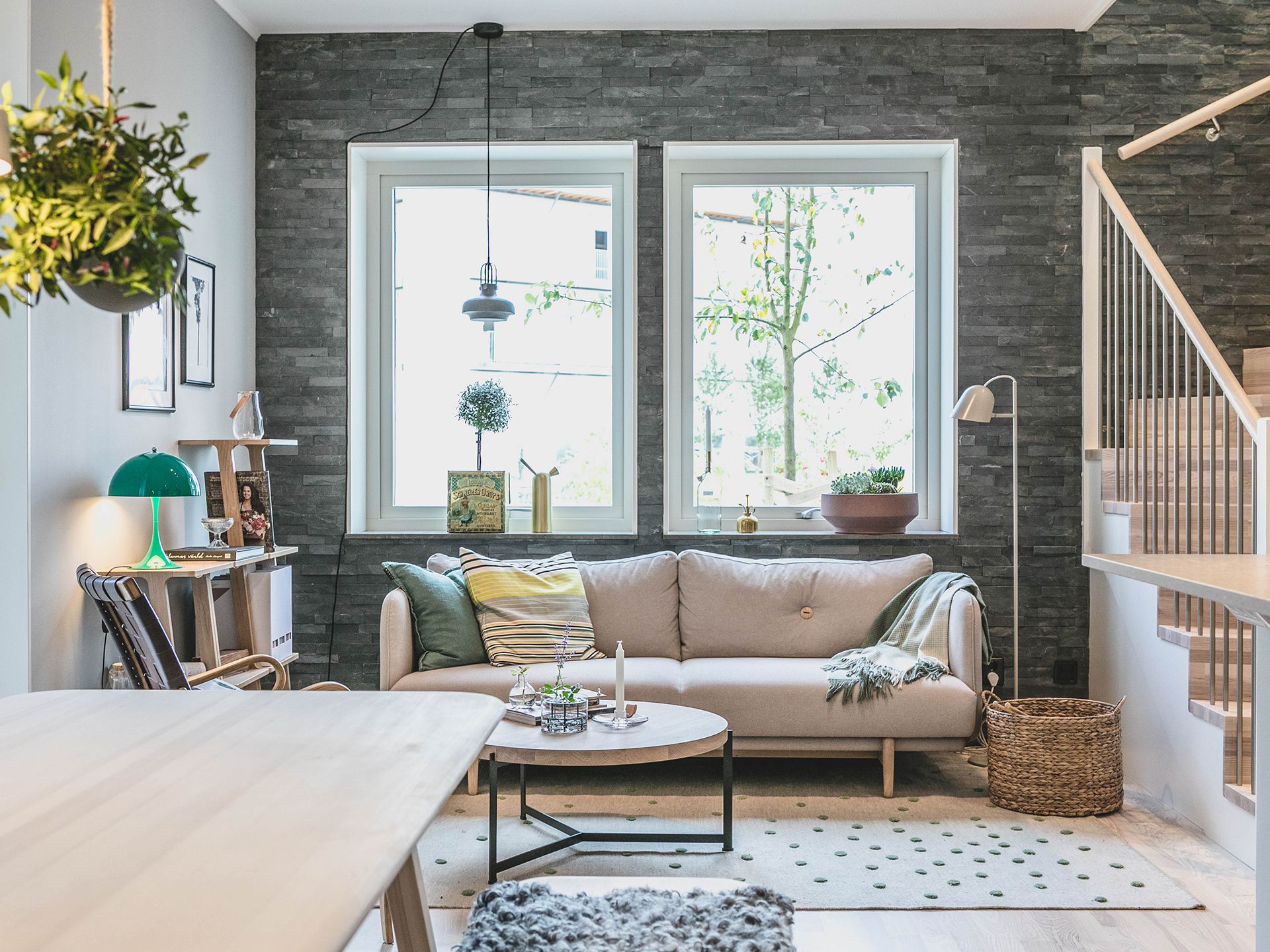 En liten beige soffa i ett vardagsrum
