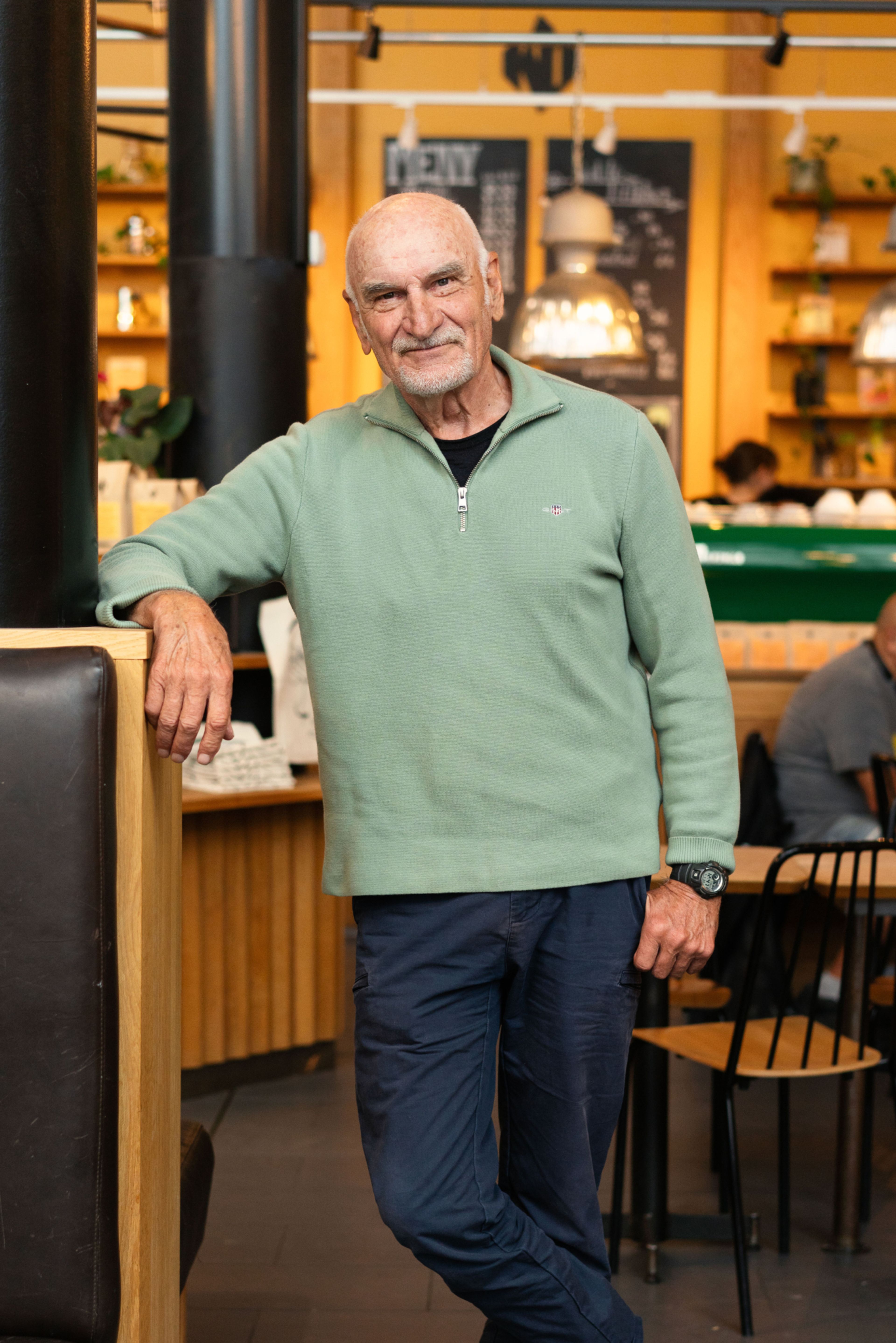 Reidar Selbekk står lent inntil en benk på Kaffebrenneriet