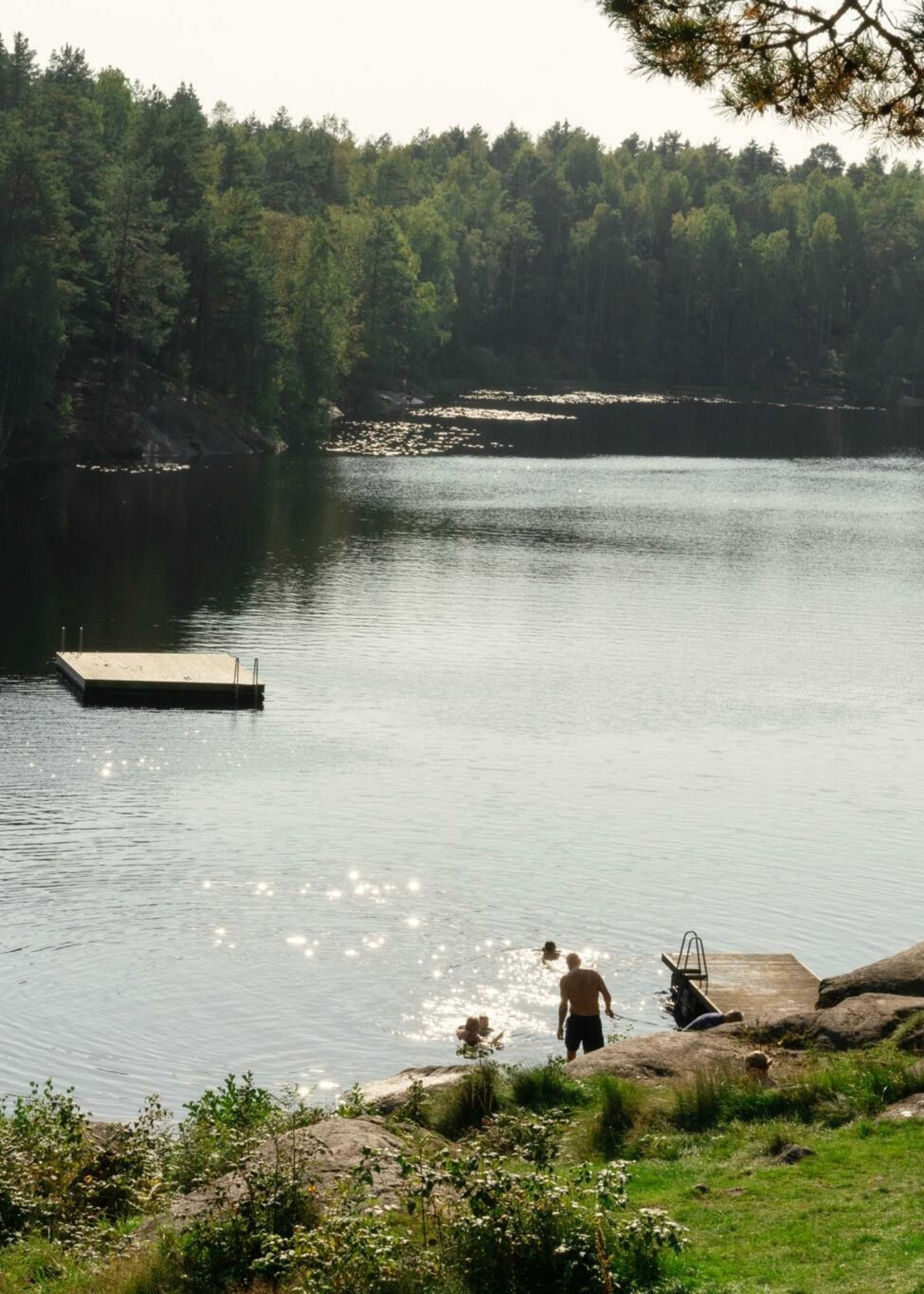 Mennesker som bader på en badeplass med flytebrygge på Mortensrud.