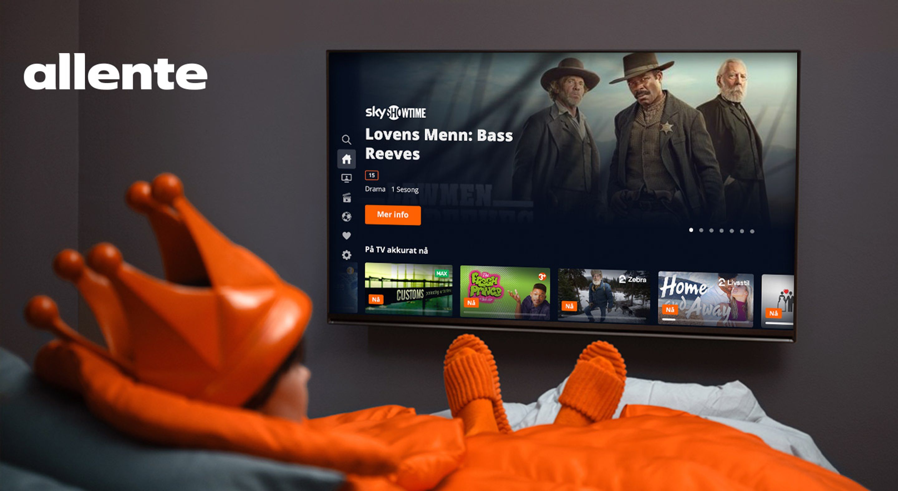 En person kledd i oransje klær ser på TV.