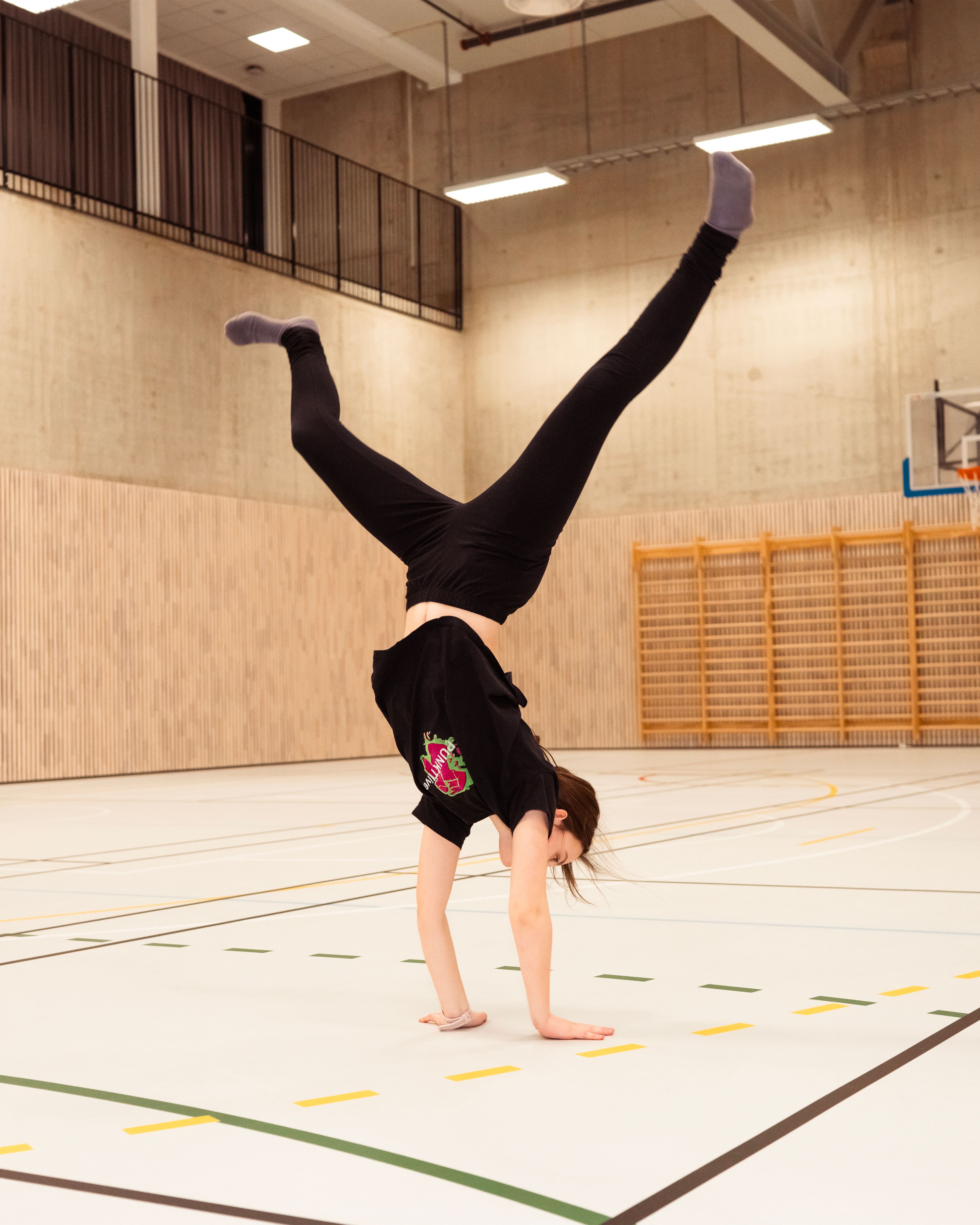Lykke Marie står på hendene i en gymsal