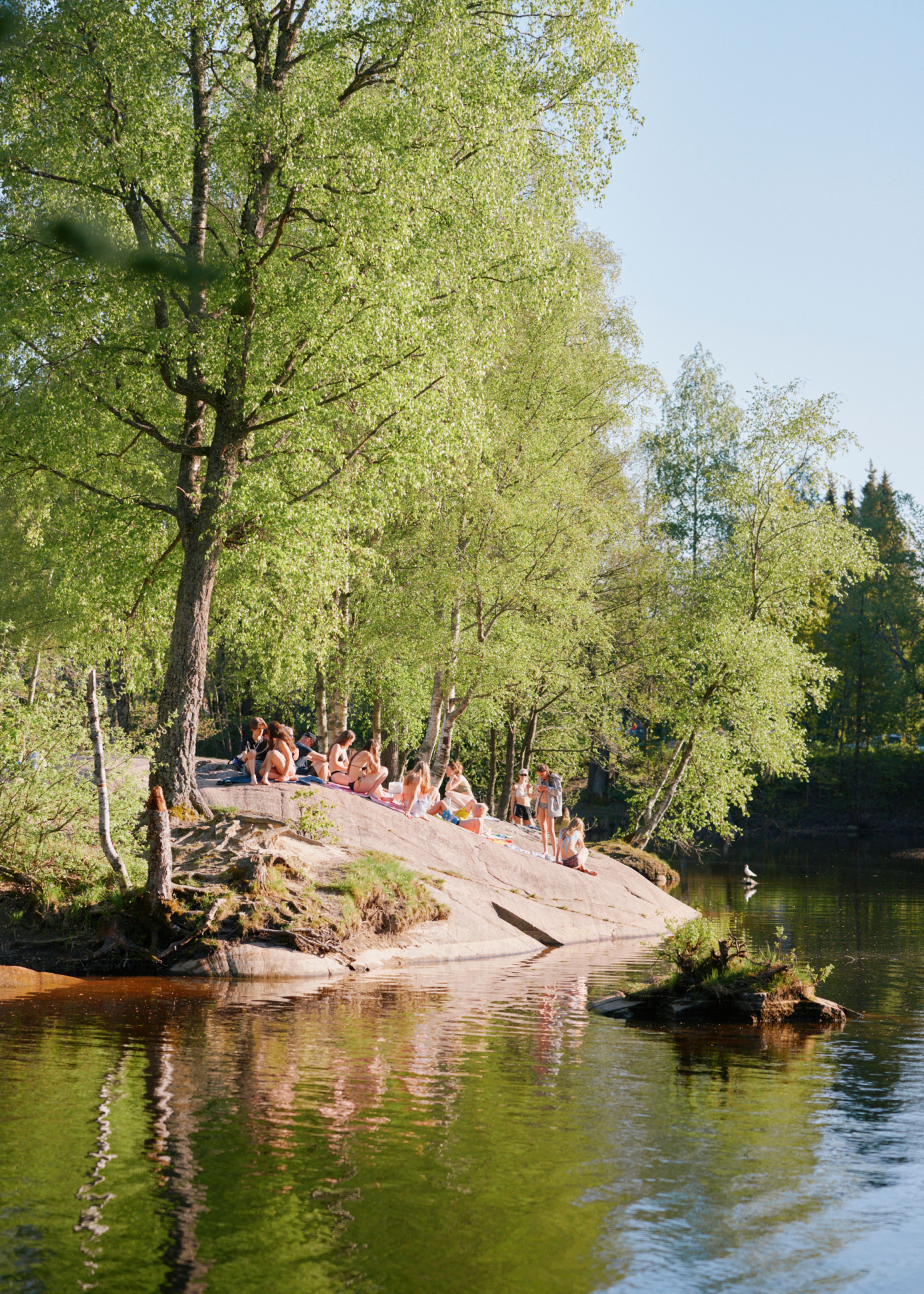 Folk som bader fra et svaberg.
