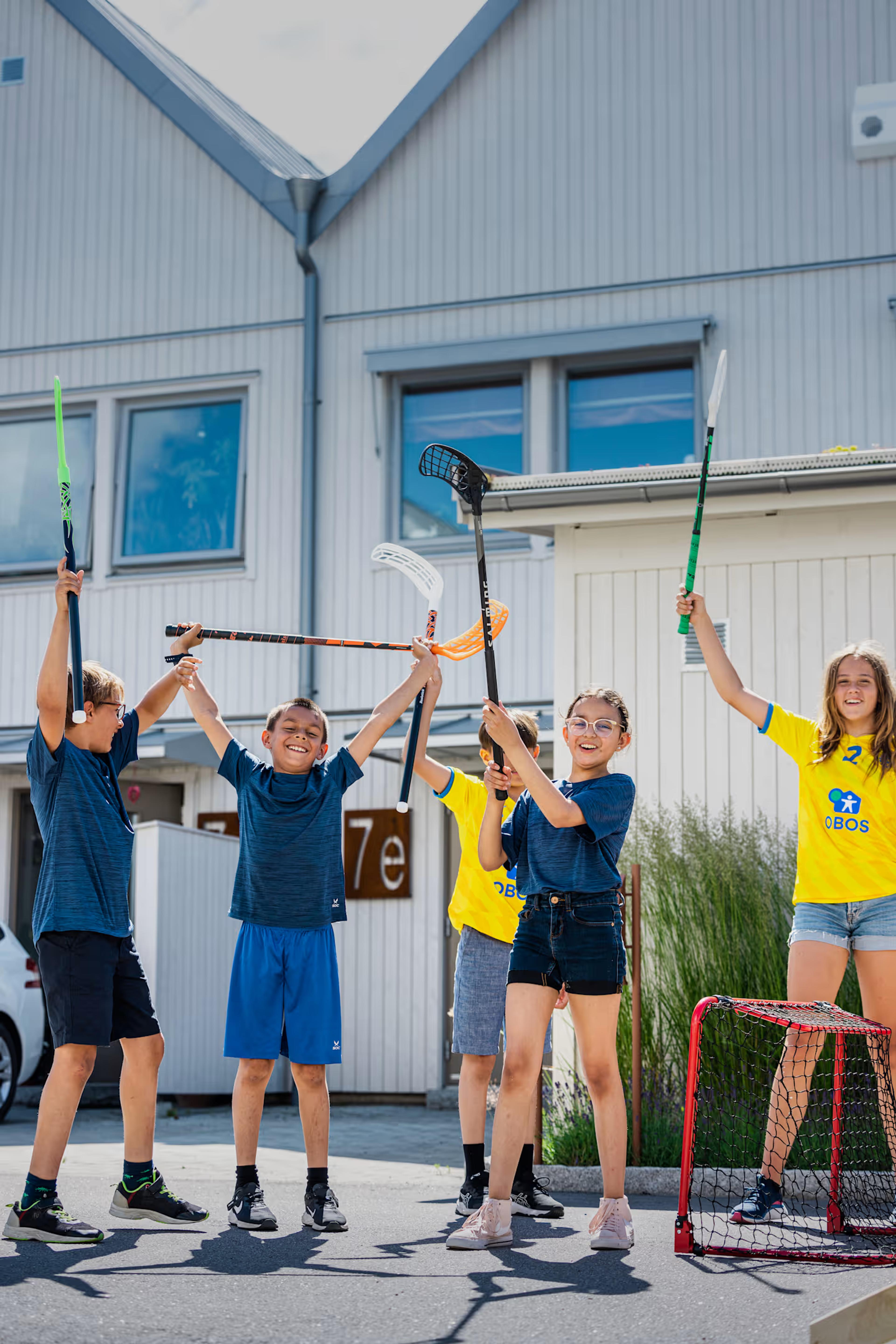 Barn med innebandyklubbor utomhus