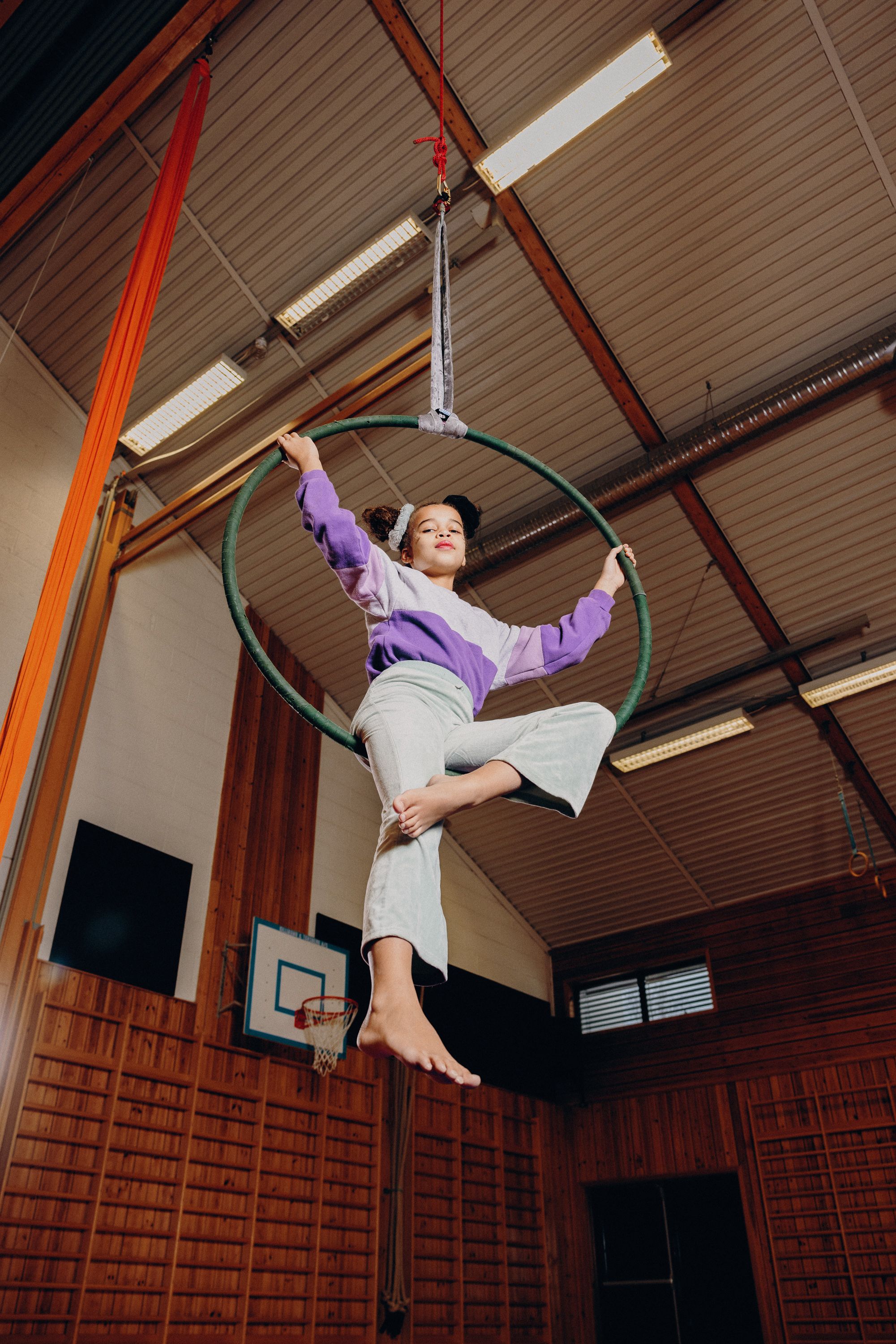 En ung akrobat henger fra taket i en akrobatring