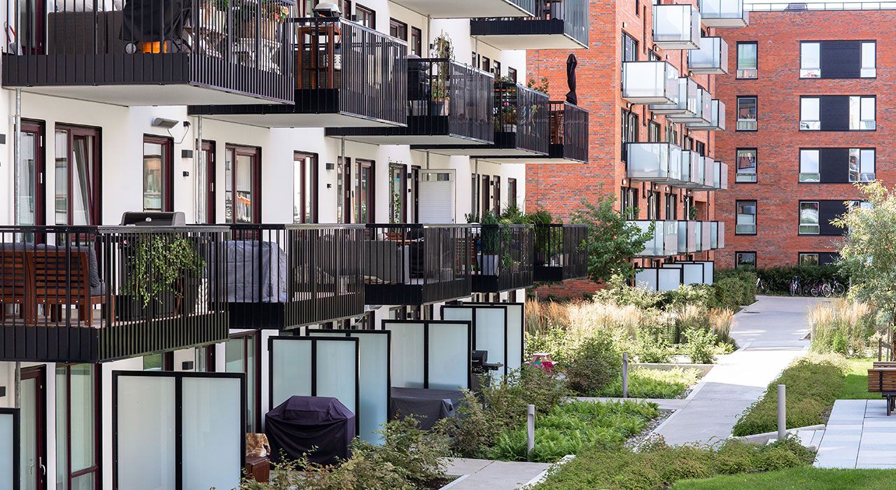 Fasaden på en boligblokk med et hyggelig grøntområde rundt