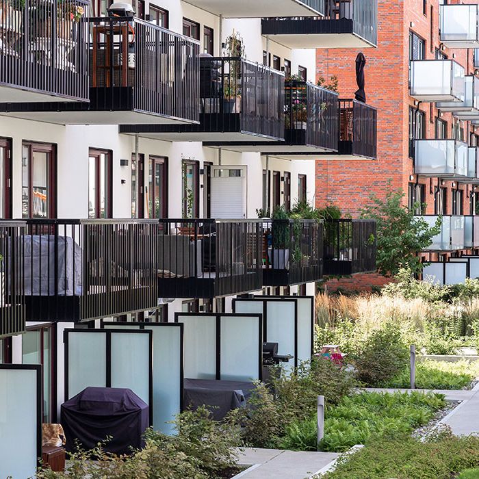 Fasaden på en boligblokk med et hyggelig grøntområde rundt