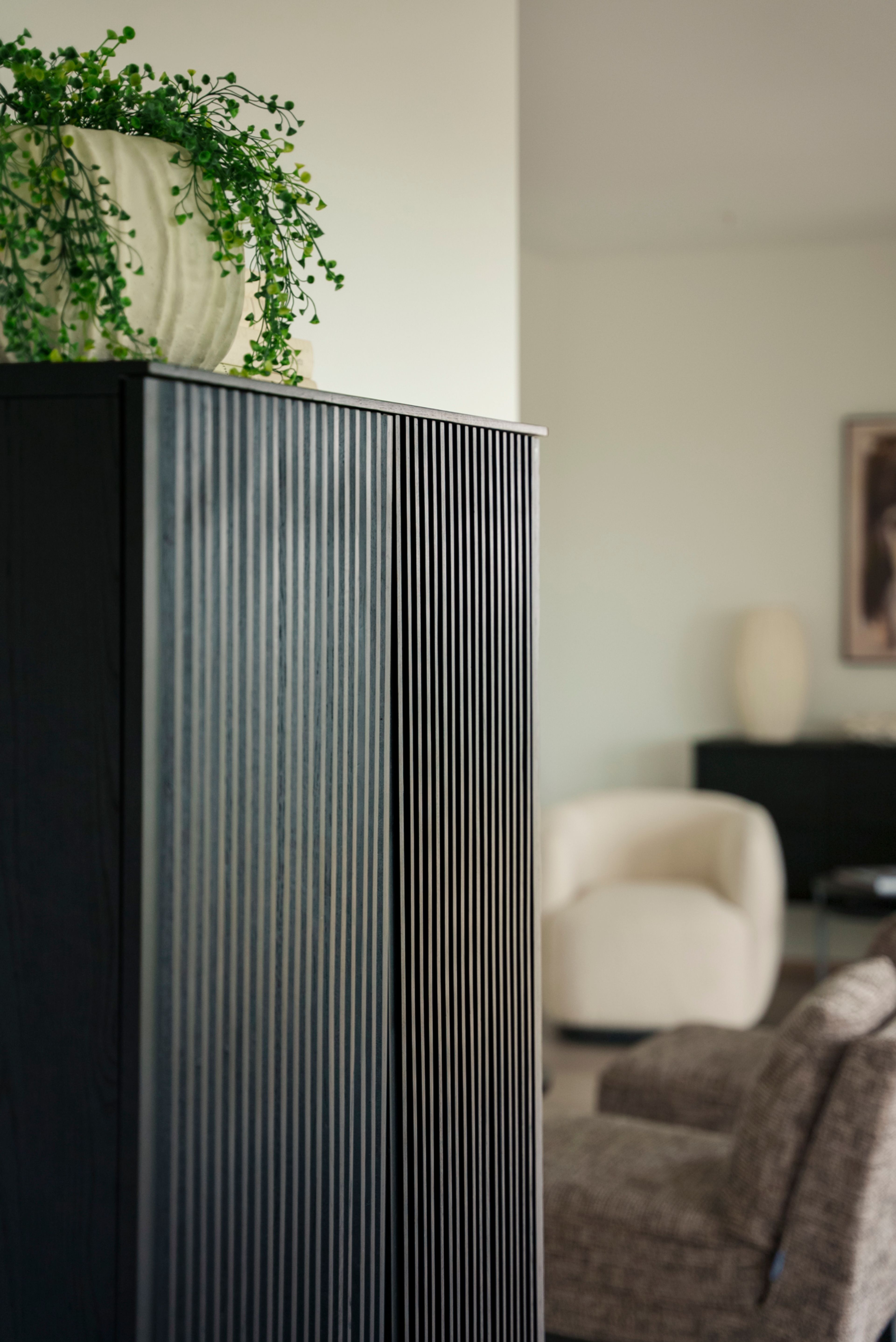 Et sort skap med spiler og en stor grønn plante på toppen.