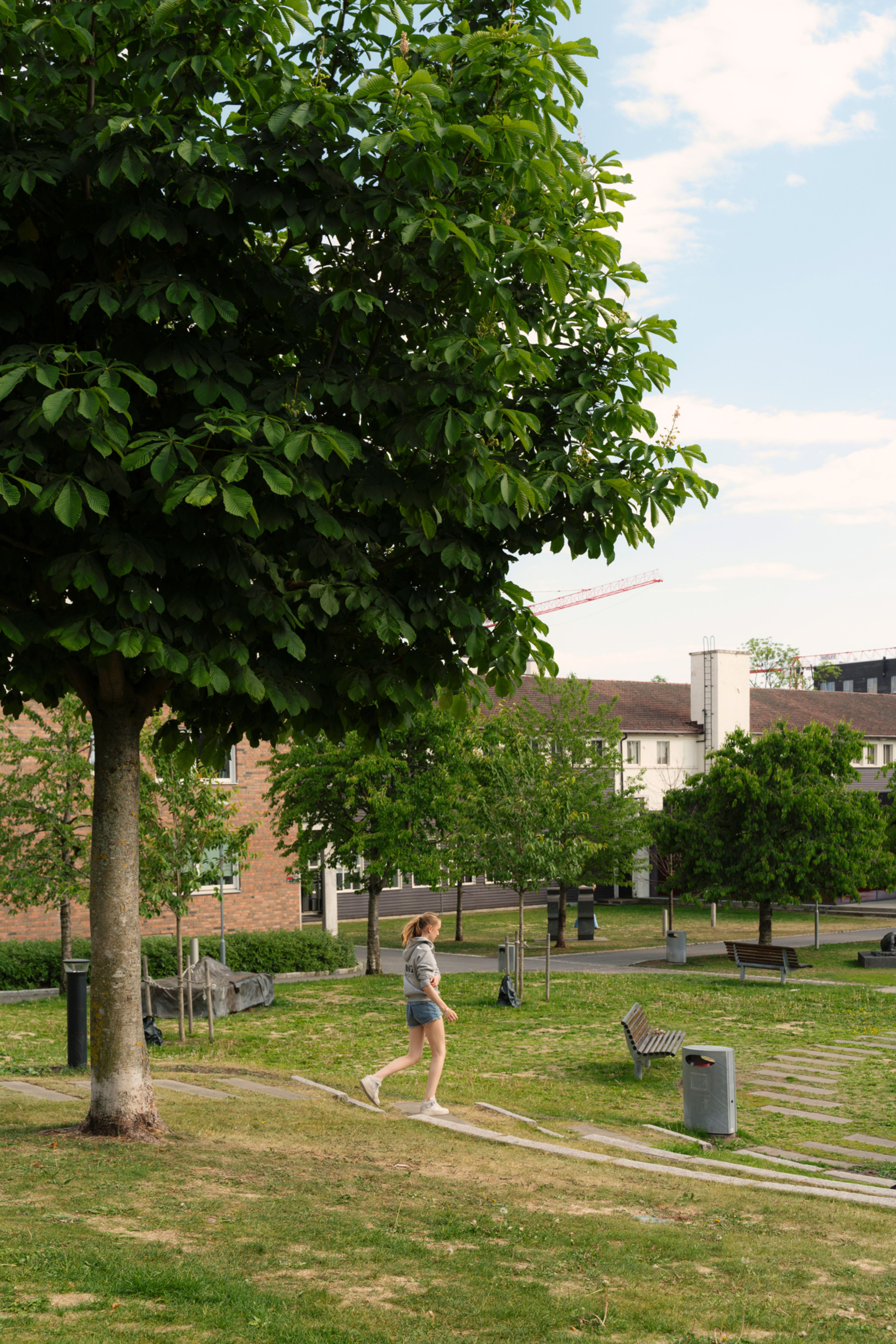 Kvinne som går gjennom en park på Løren