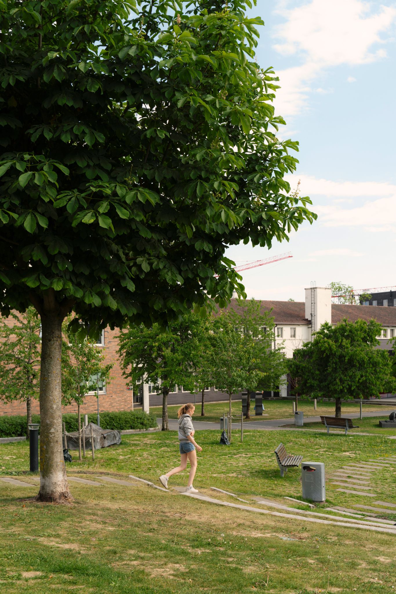Kvinne som går gjennom en park på Løren