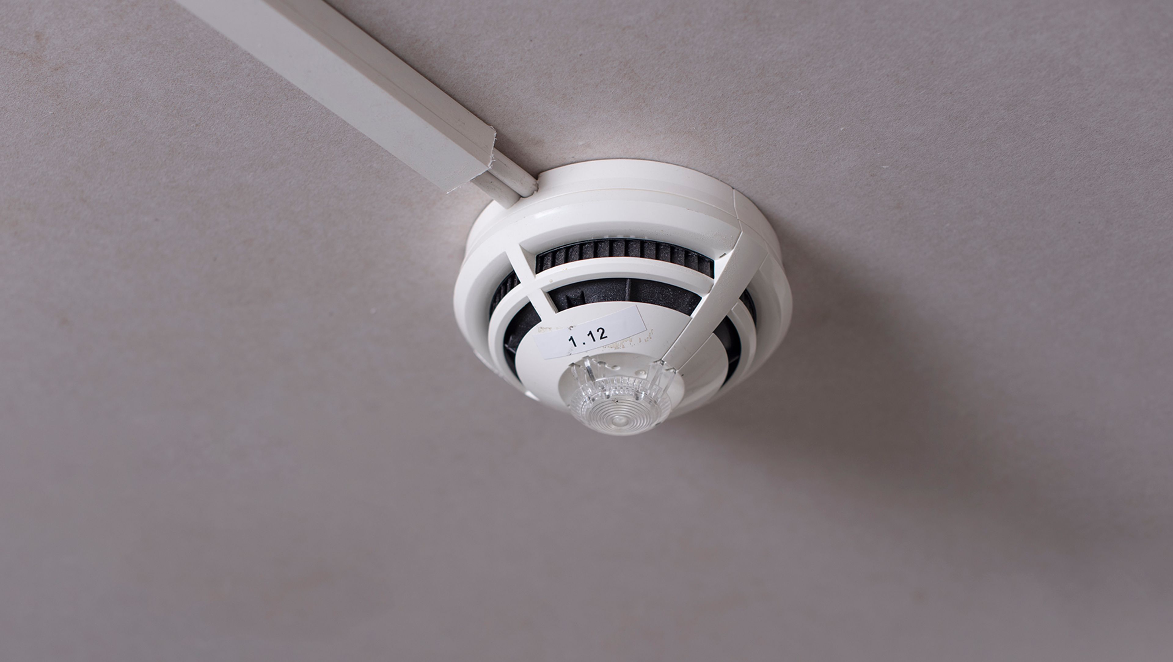 Seriekoblet røykdetektor montert i tak i bygård.