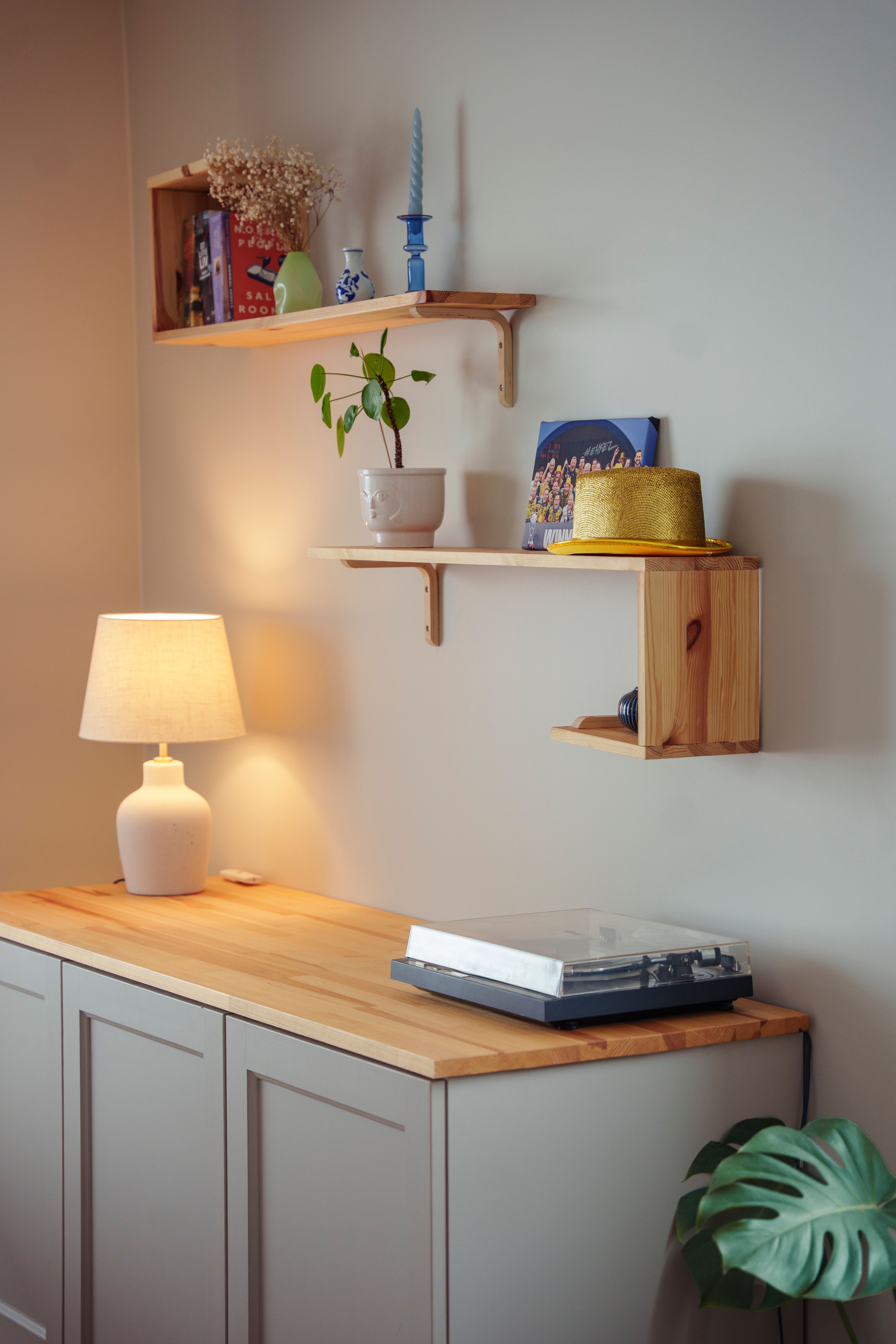 Nærbilde av et stuehjørne med en kommode og hyller