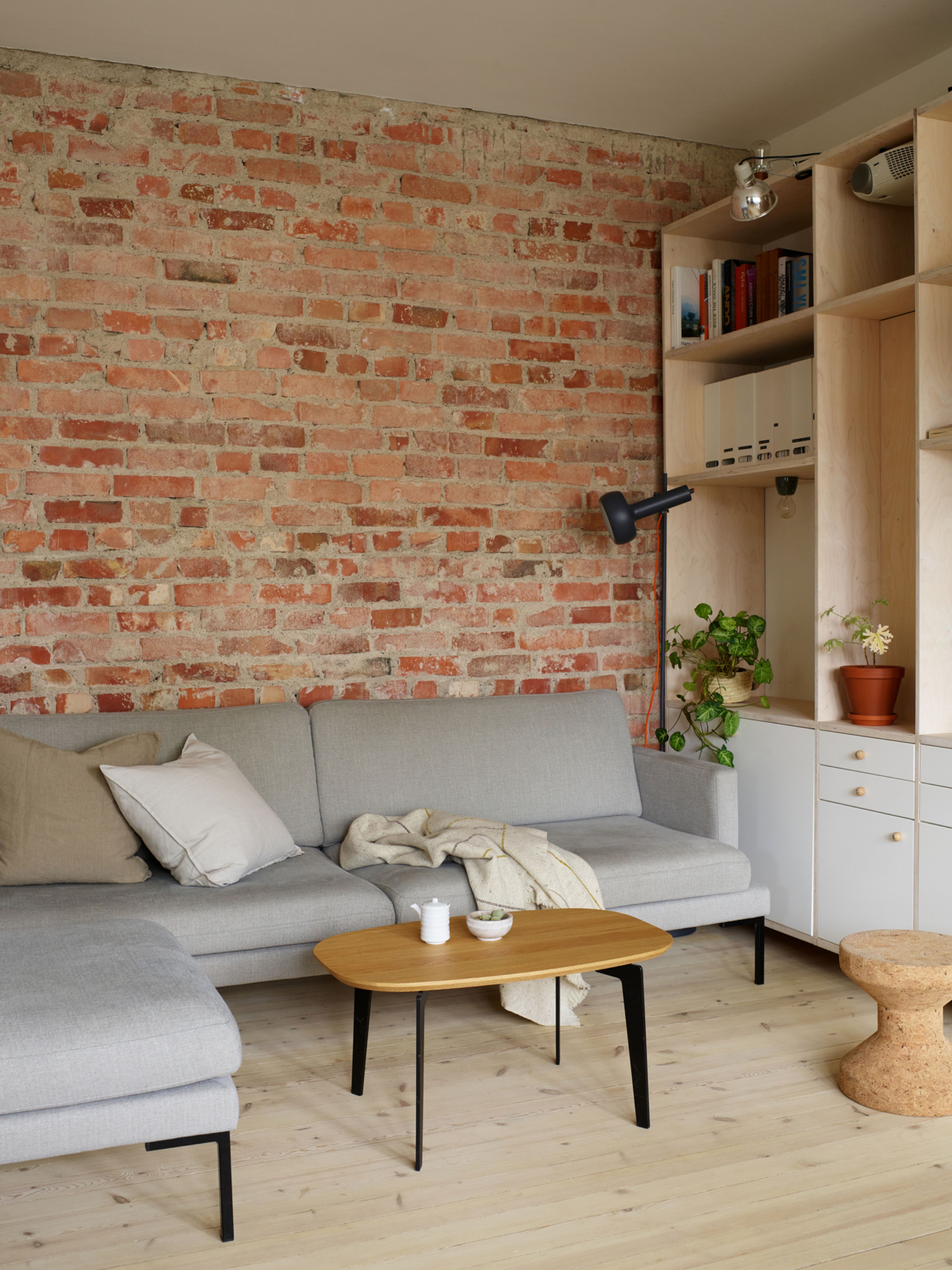 Bildet viser et stuehjørne med sofa og hyller.