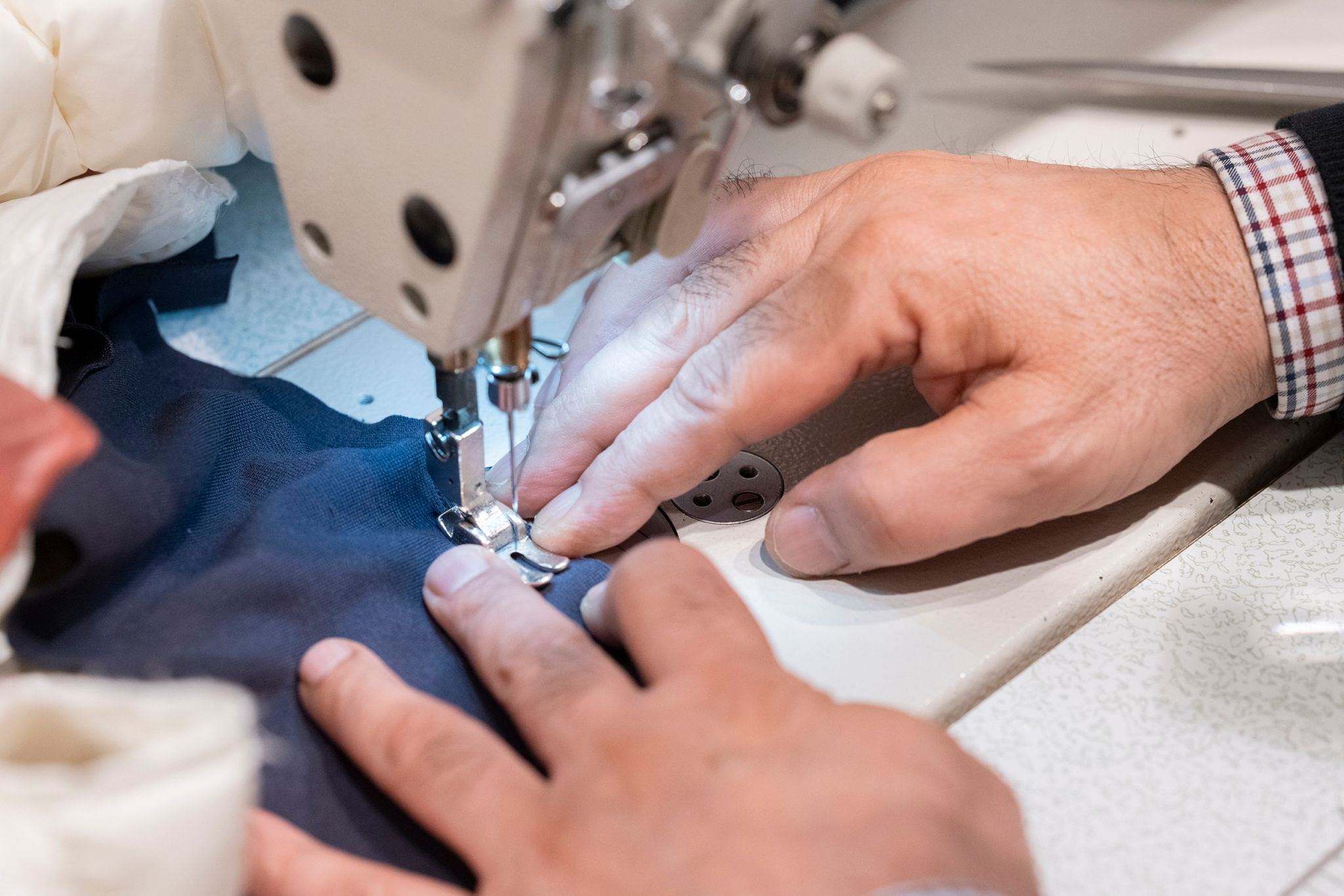 Bildet viser et nærbilde av Sames hender som syr.