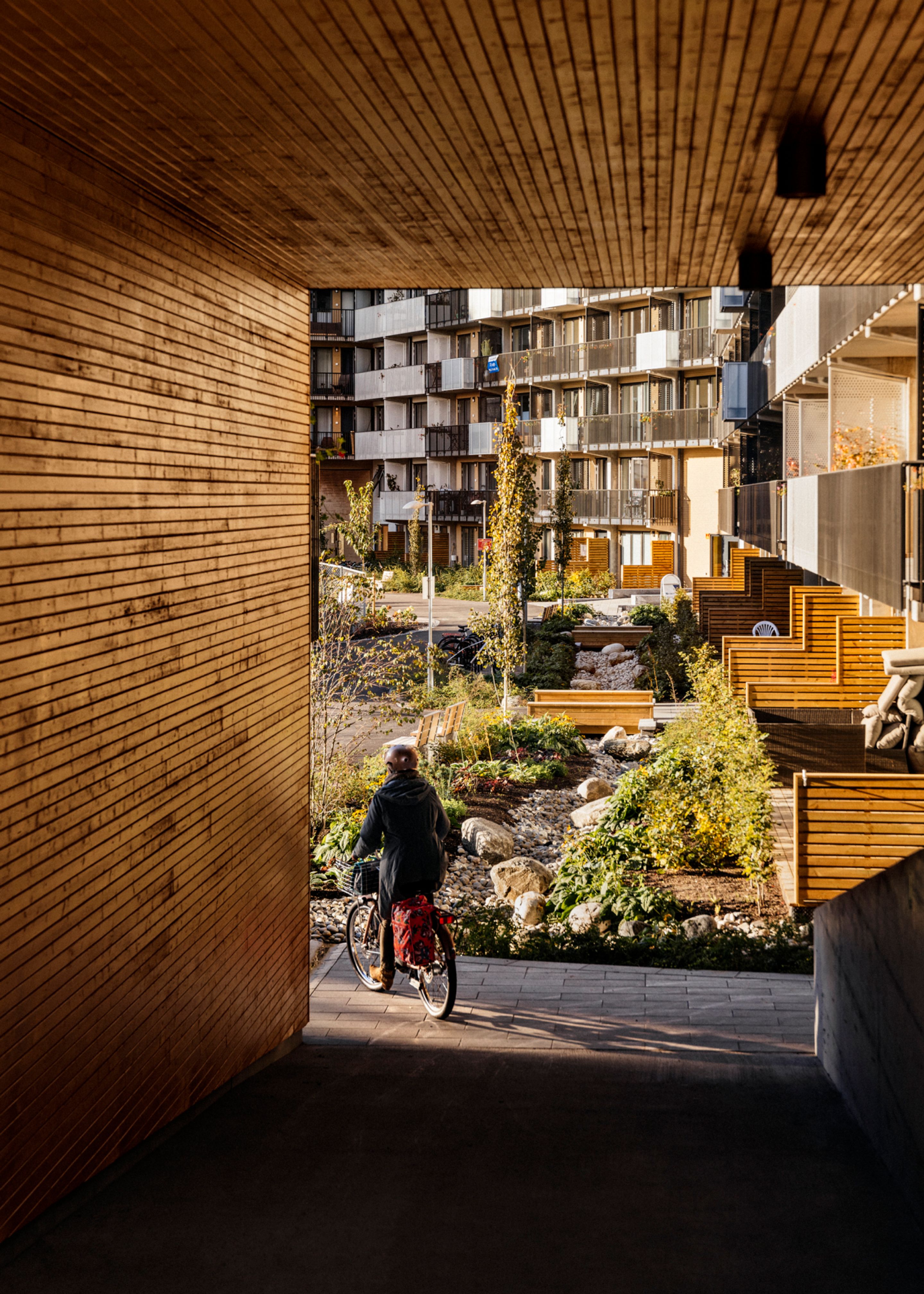Bildet viser en person som sykler inn i et gårdsrom på Ulven i Oslo.
