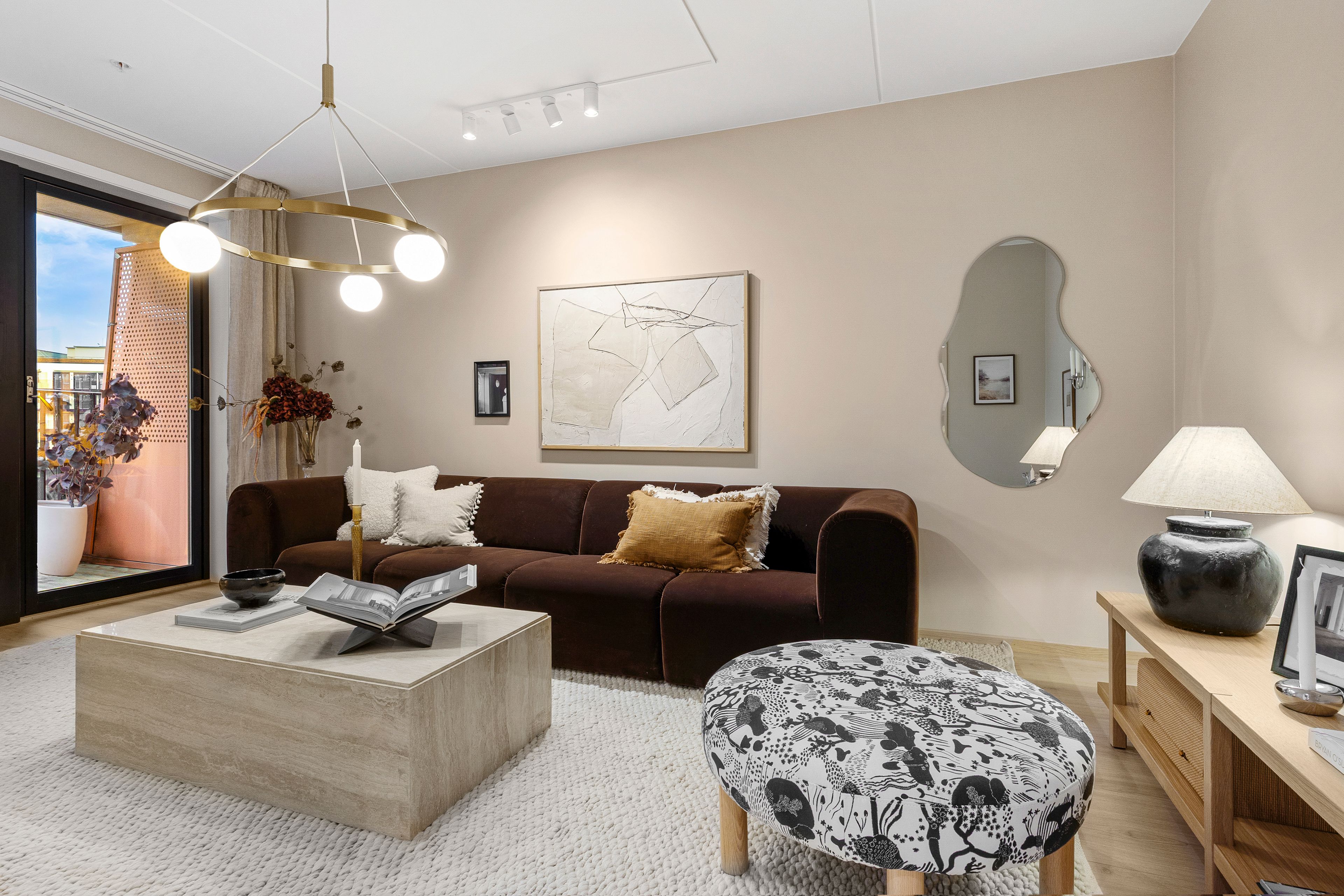 Stue med sofa, sofabord og puff.