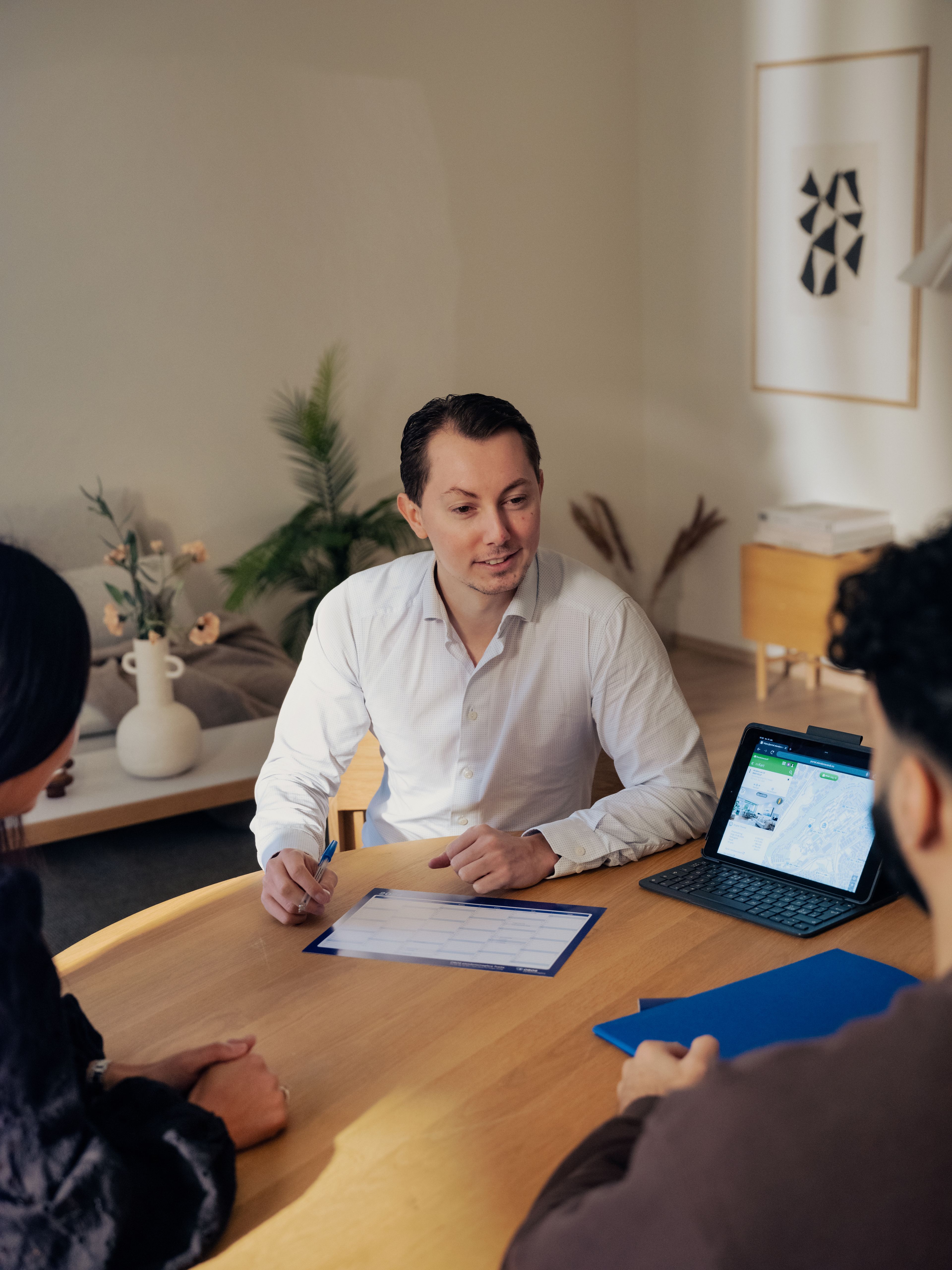 En megler viser frem salgsprospekt for kjøpere