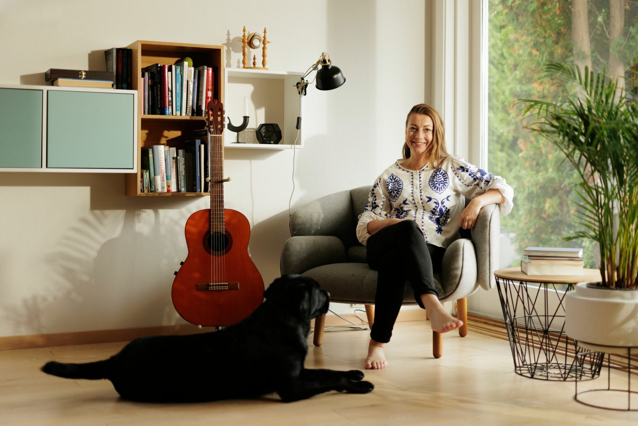 Portrett av Silje Strand Ekelund, leder for personmarked i OBOS-banken, hjemme i stua sammen med hunden sin.