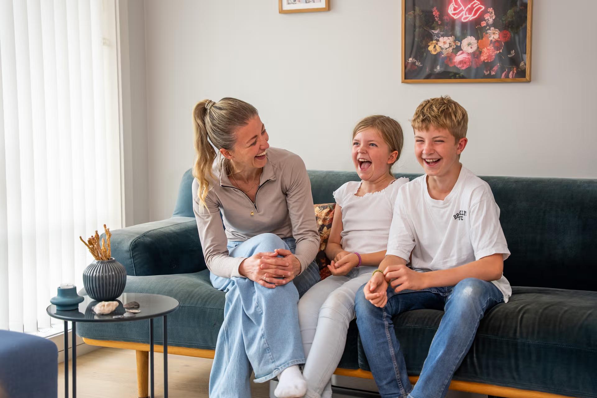 Mor og to barn ler sammen