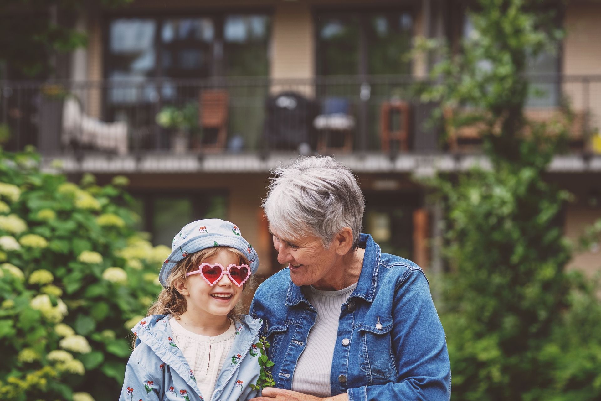 Barnebarn og bestemor sitter ute og prater sammen.