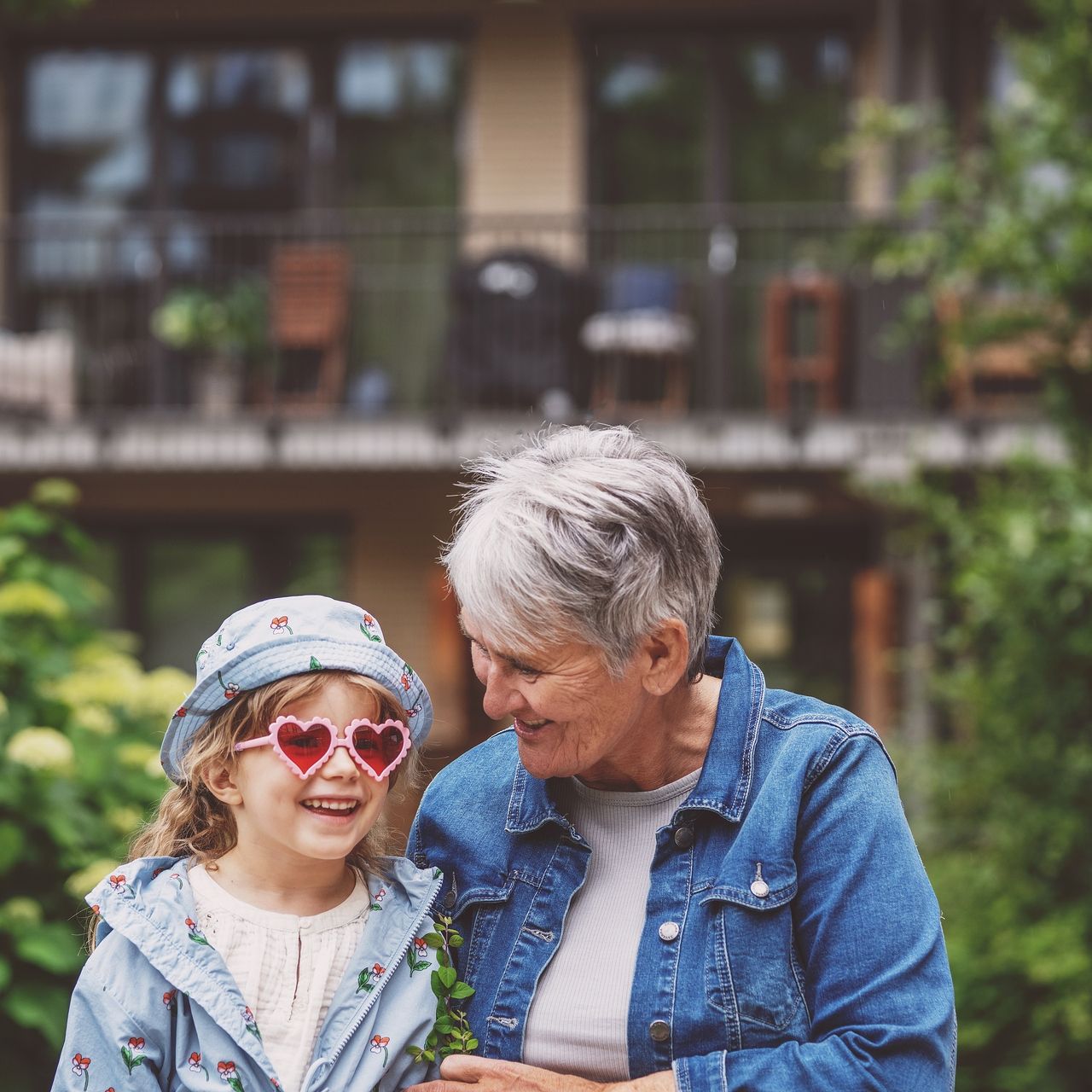 Barnebarn og bestemor sitter ute og prater sammen.
