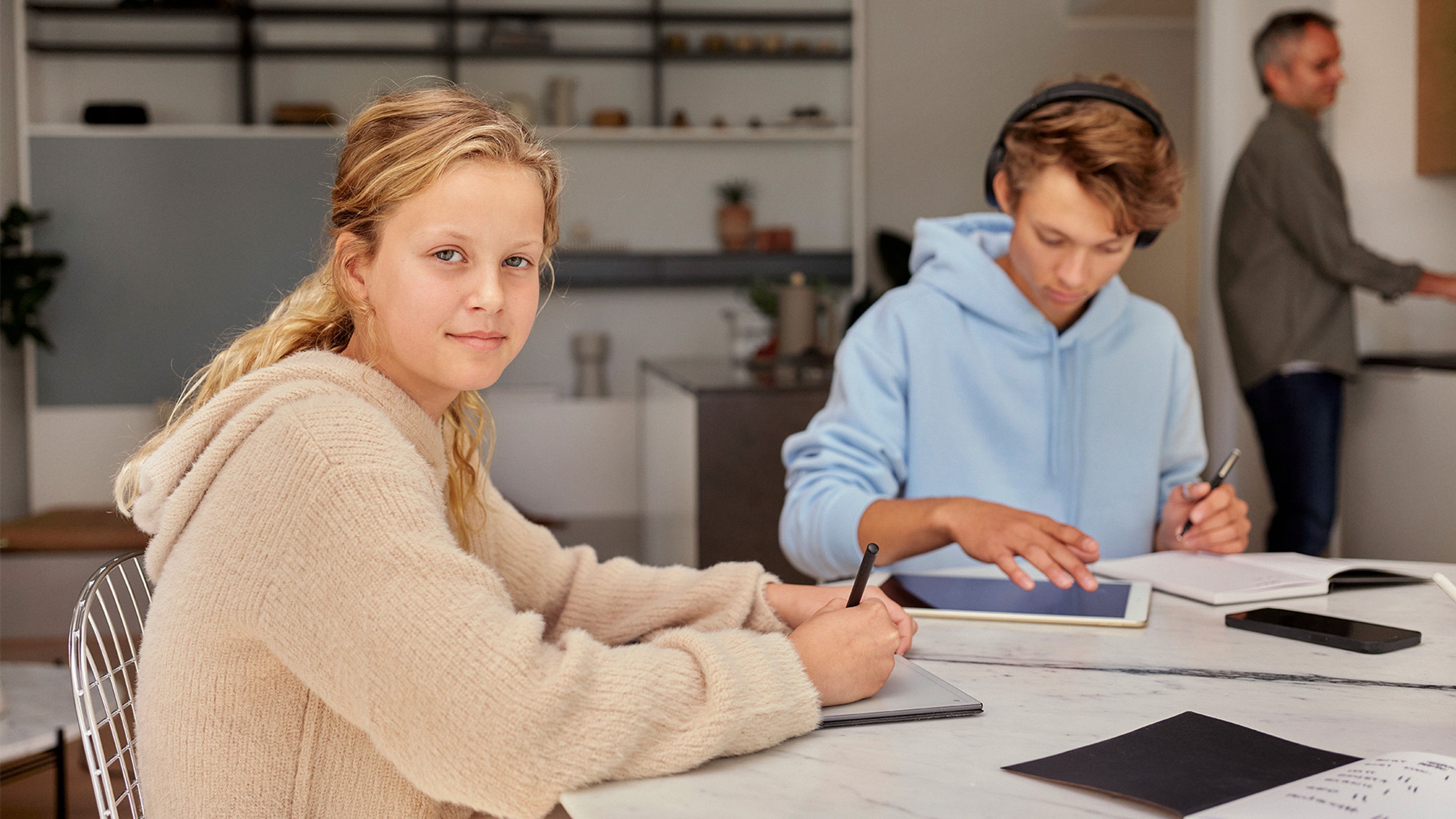 barn som sitter v köksbord med Ipads