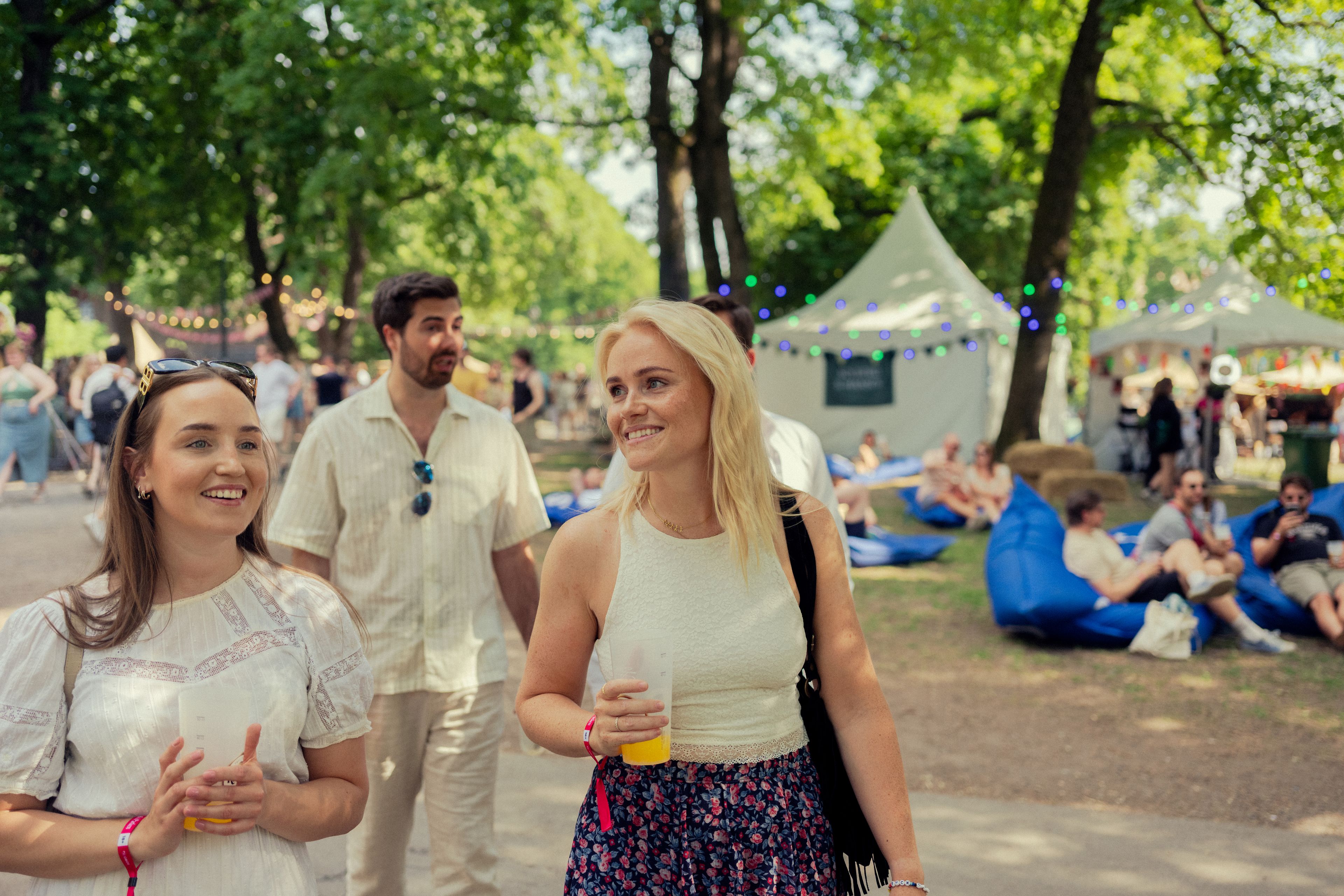 Tre blide folk i solskinn på festival