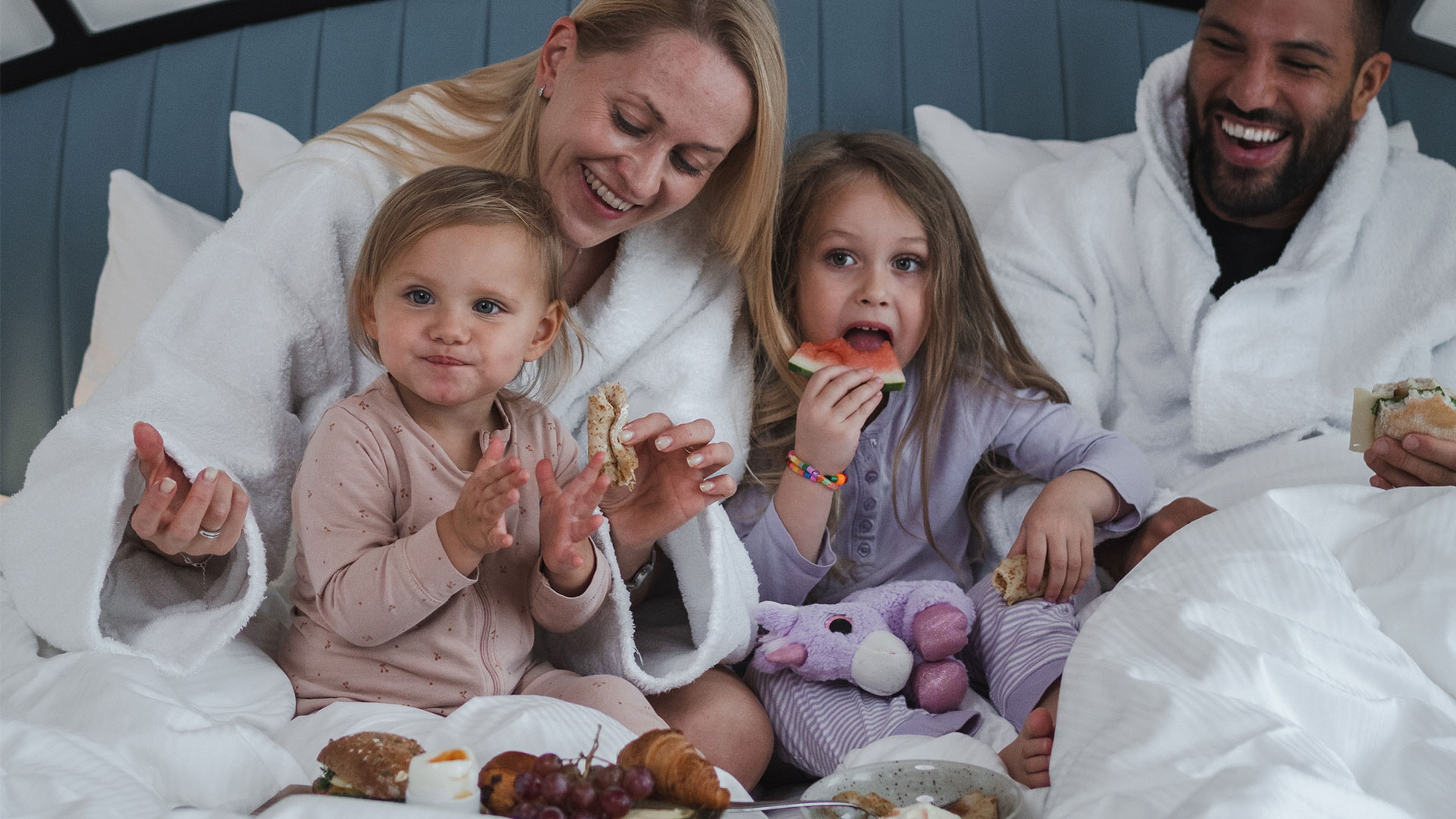 Familj som äter frukost i sängen