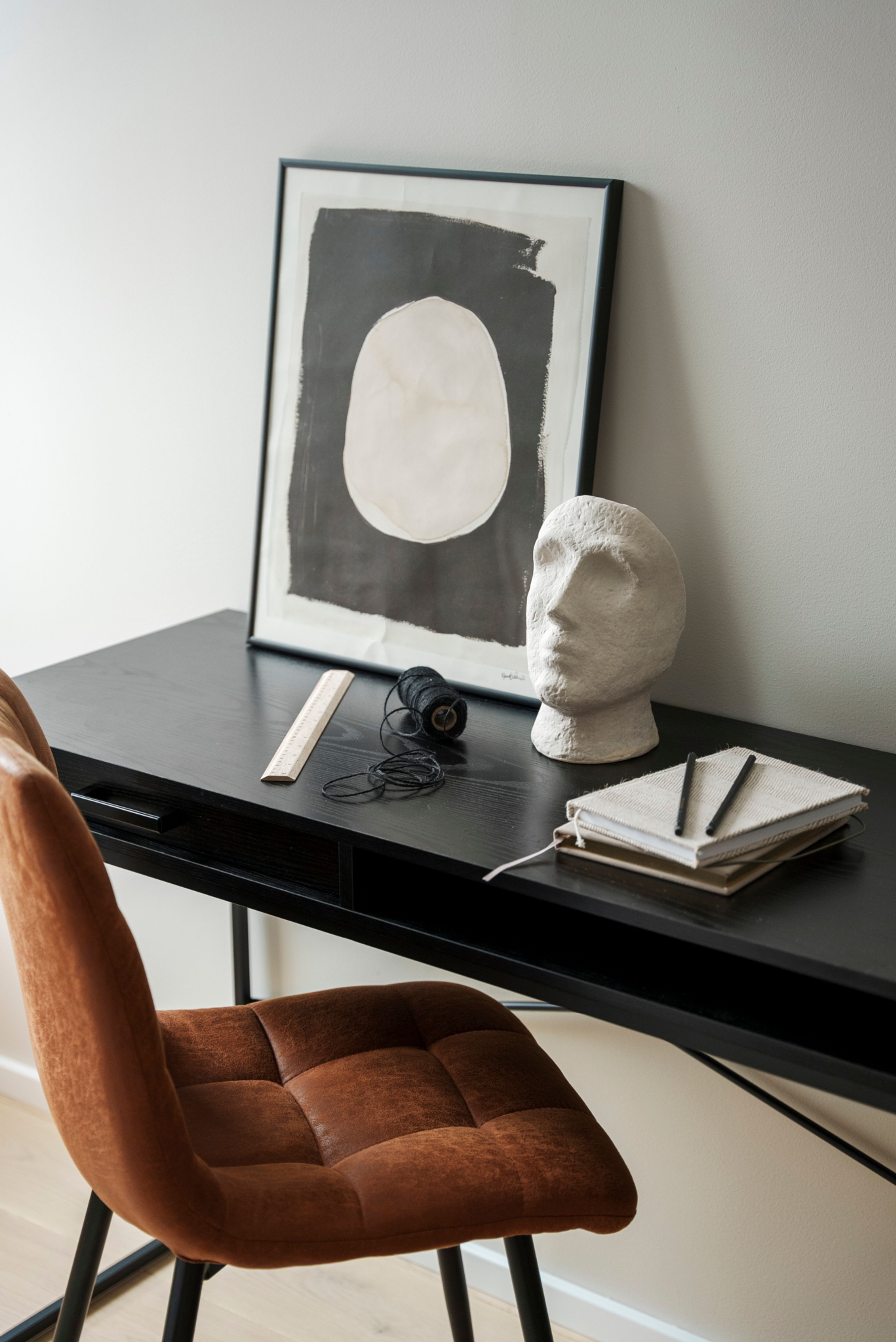 Et skrivebord med pyntegjenstander og bøker i MIDT.