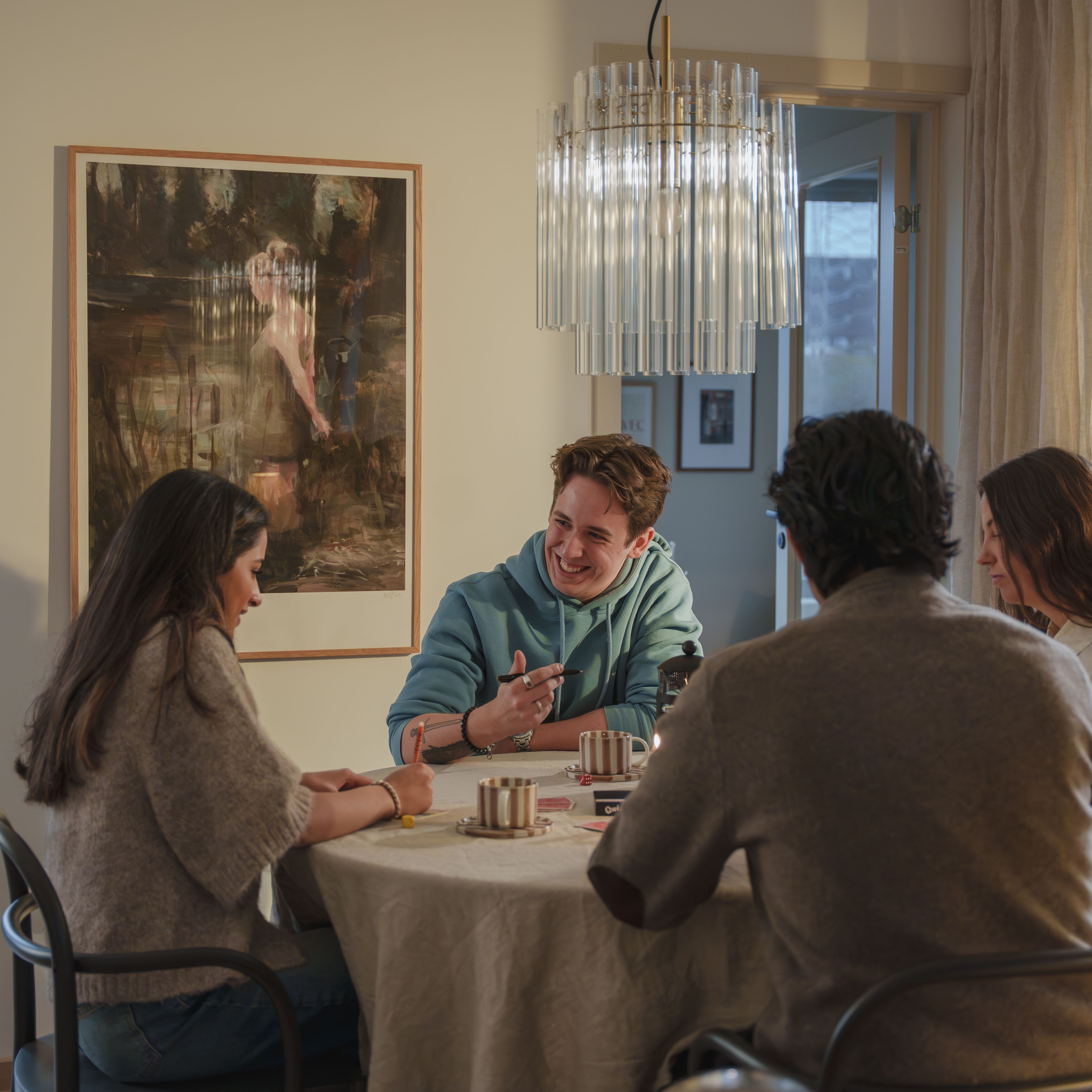 Fire unge mennesker sitter rundt et bord