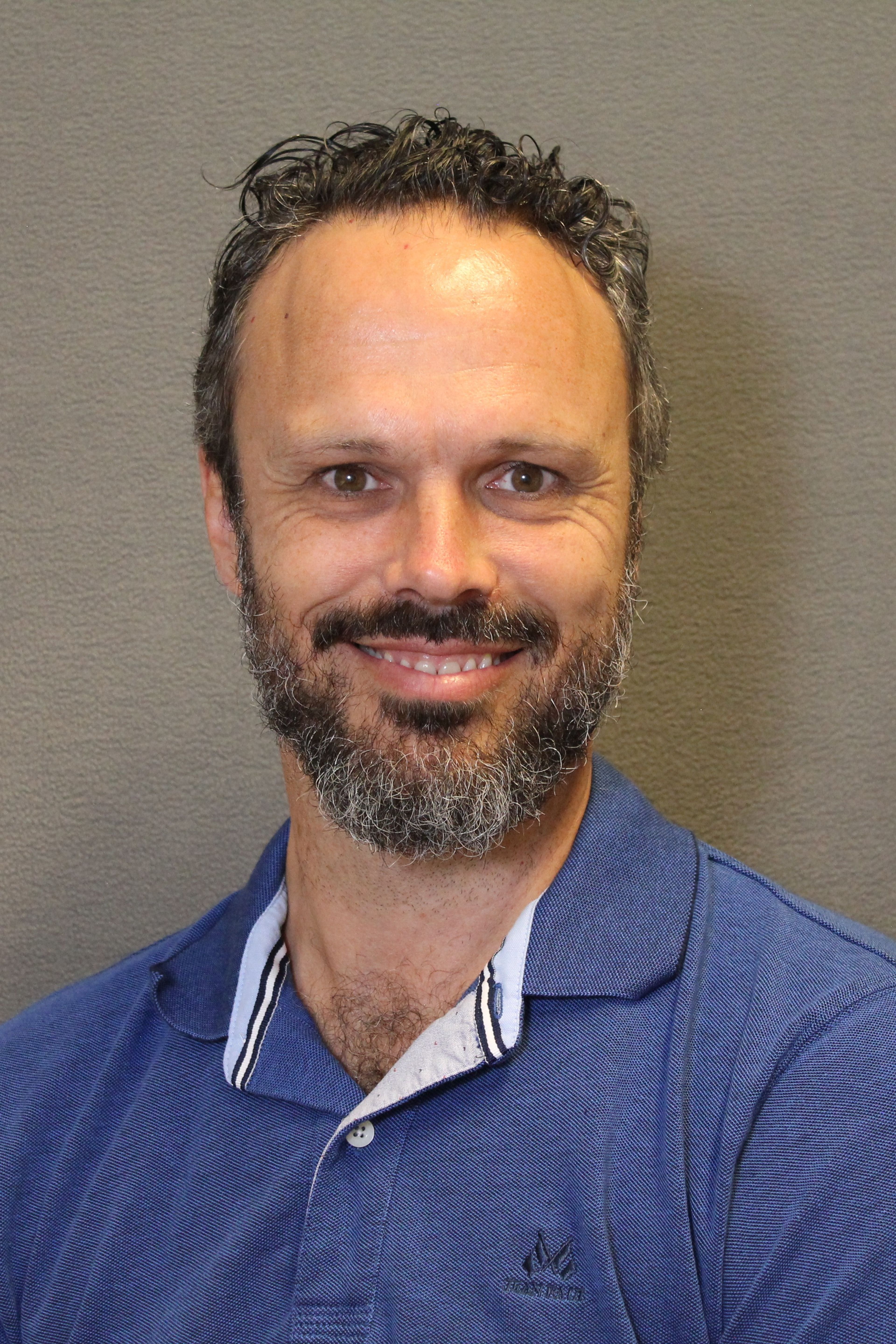 Johan Hake. En mann som har på seg et blå pikeskjorte og smiler