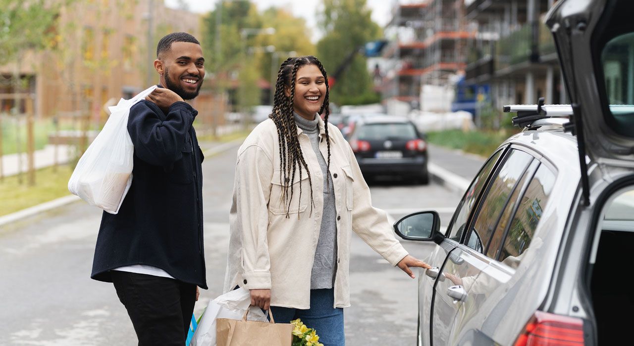 Lykkelig par med handleposer på vei inn i bilen