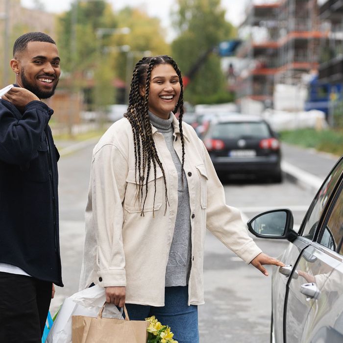 Lykkelig par med handleposer på vei inn i bilen