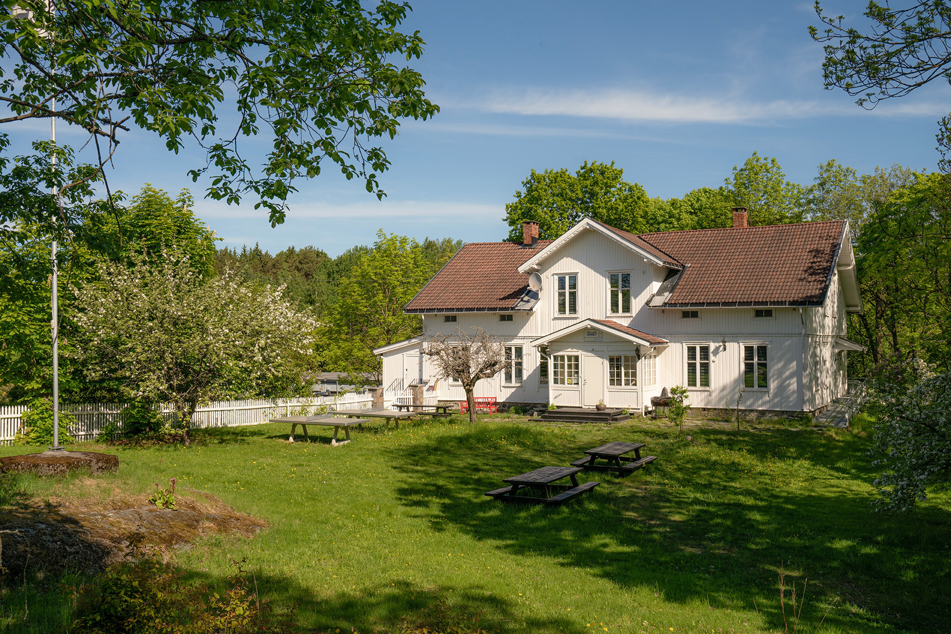 Foto av hovedhuset på Mortensrud Gård på sommeren.